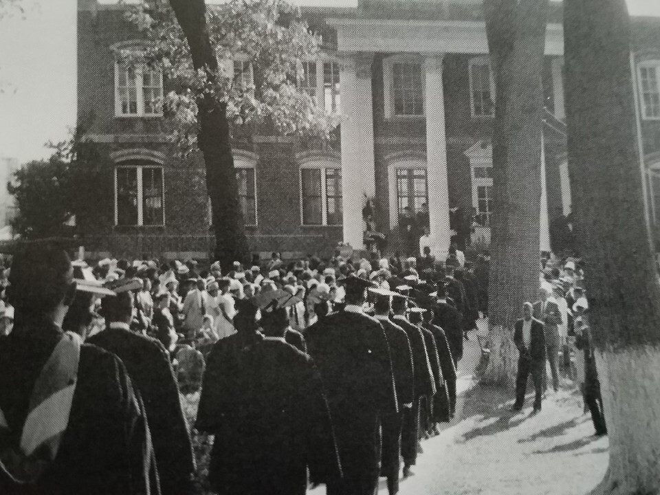 historical image of graduates walking into a college building
