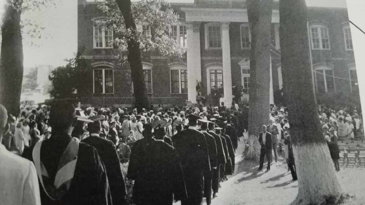 historical image of graduates walking into a college building