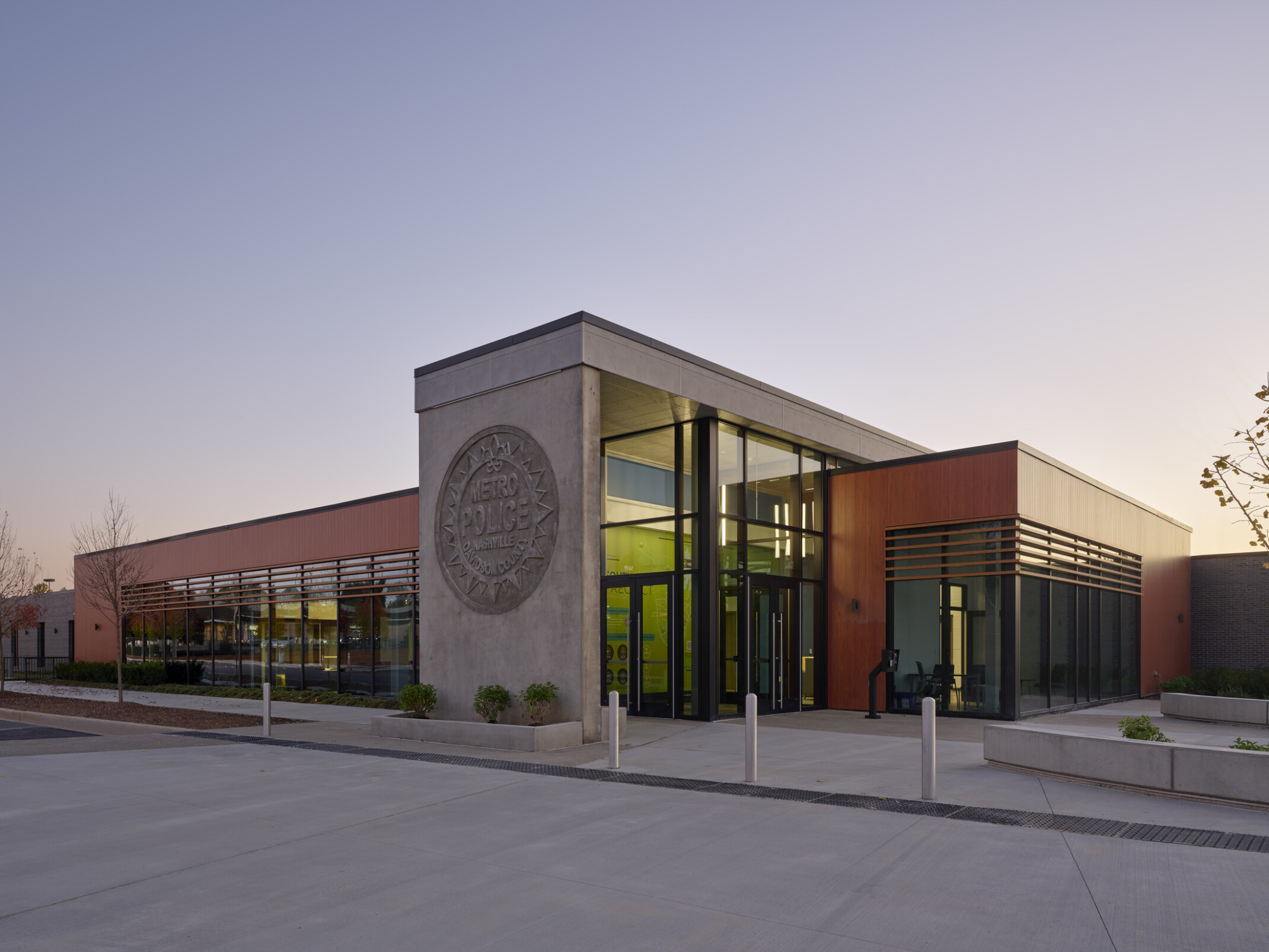 front entrance of a modern police precinct building; precast concrete, glass, and wood adjacent to public plaza