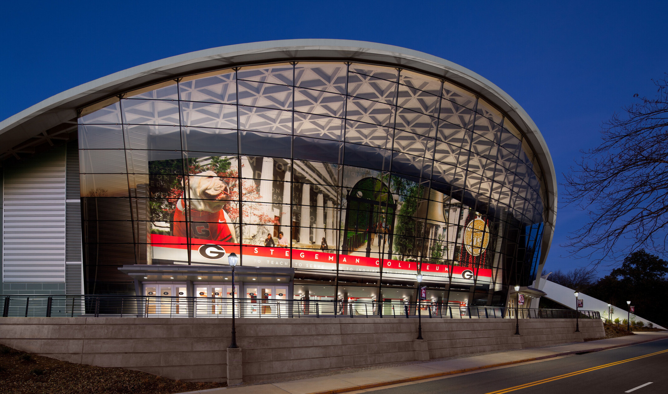 Front entrance of the University of Georgia Stegeman Coliseum; large curved glass wall with digital screen of UGA brand