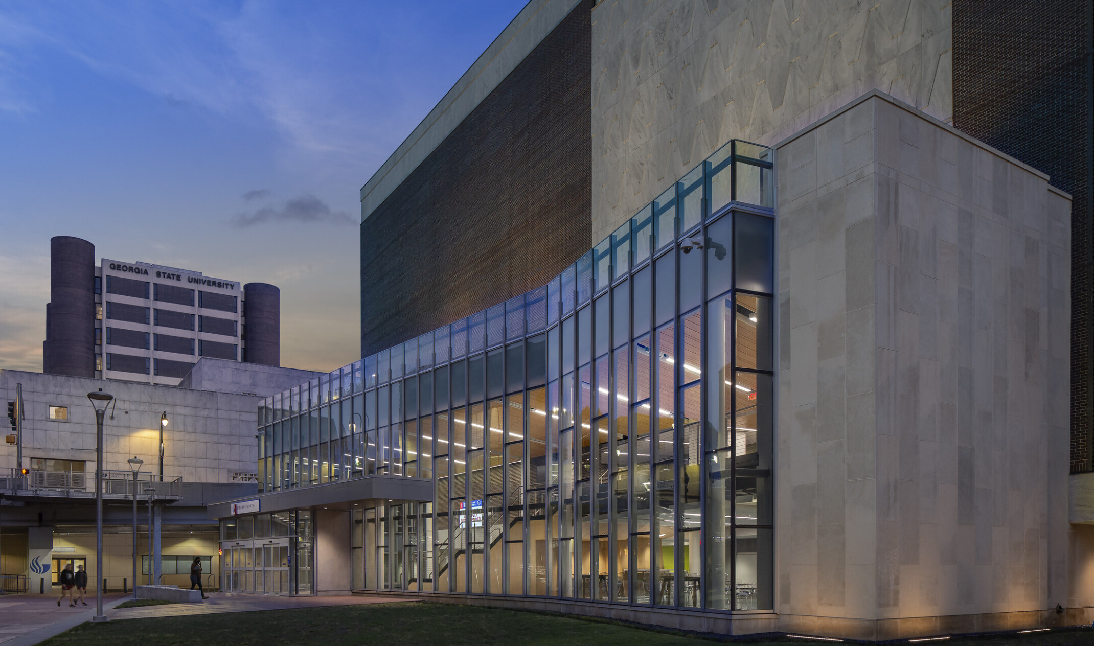 evening entrance to a higher education building with a full floor-to-ceiling window facade