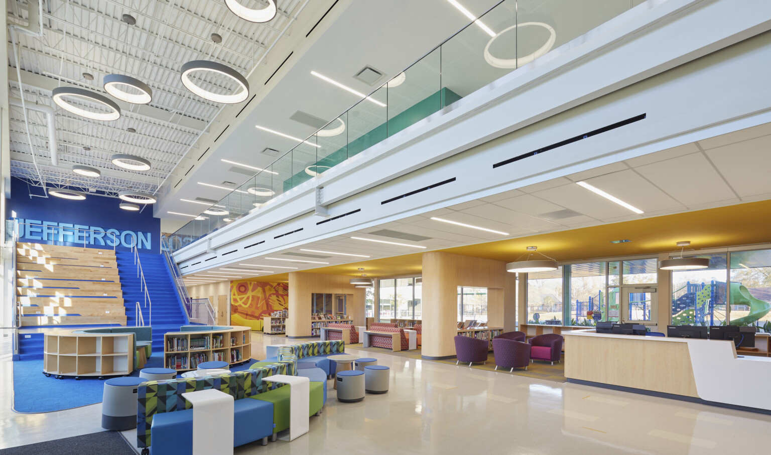 high-ceilings, custom lighting, large open-concept school learning center with multiple seating areas for privacy and collaboration