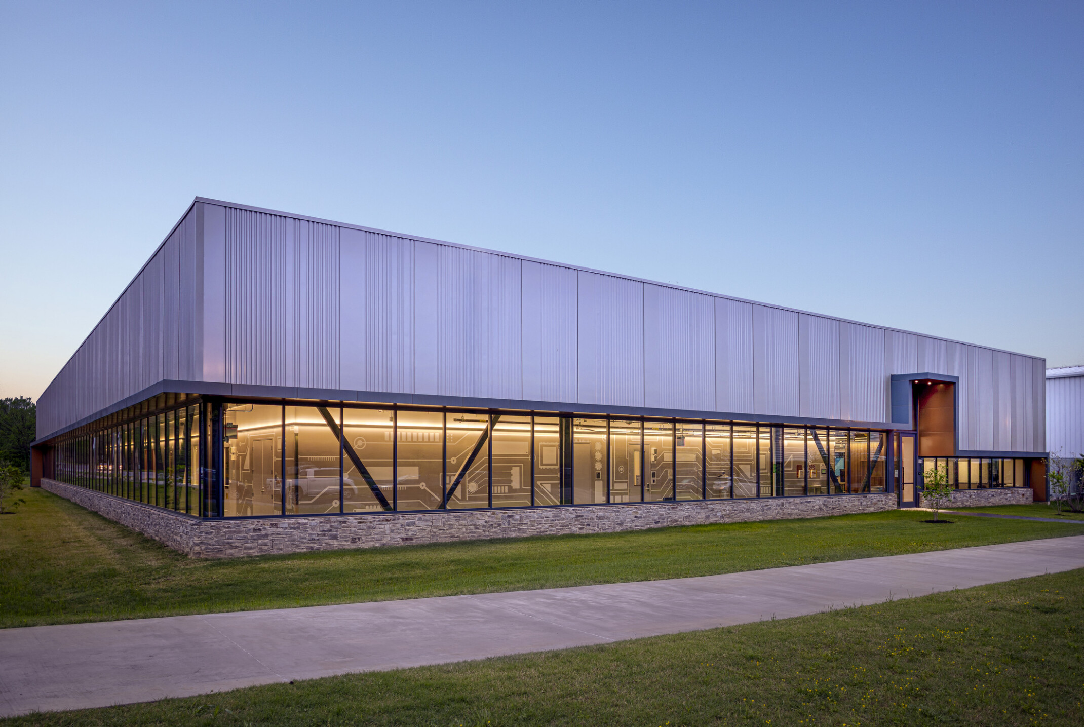 exterior rendering of a lab facility with a recessed floor to ceiling window first floor and steel second floor separate by an awning; people walking in the forefront of the building