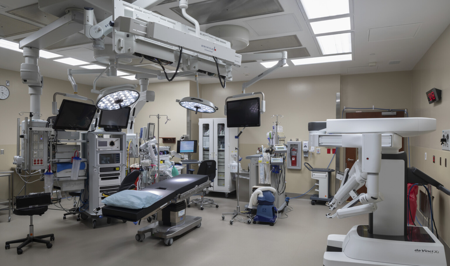Operating room with equipment hanging over bed and along beige walls Operating room with equipment hanging over bed and along beige walls