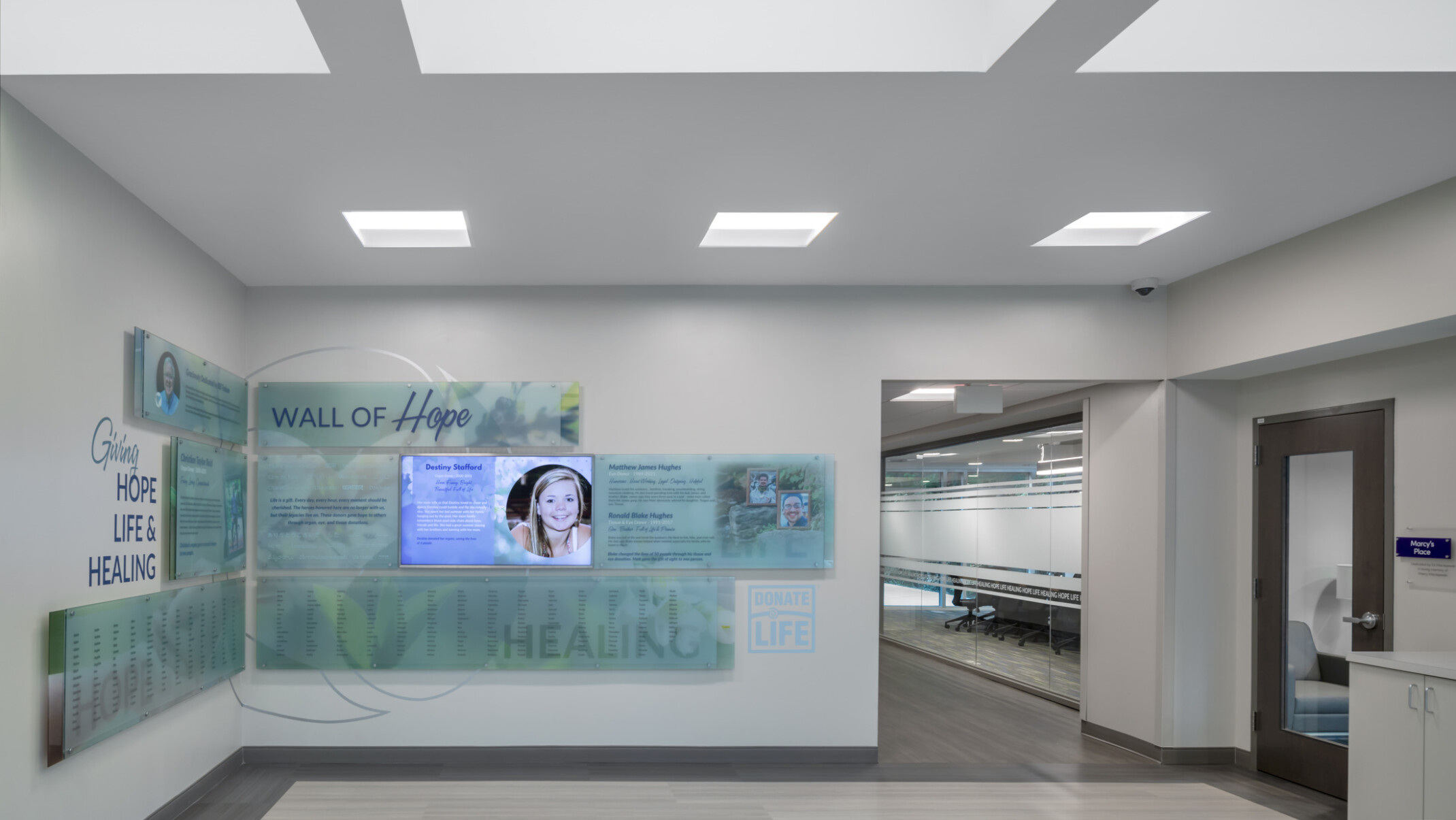 Hospital waiting area with square lighting on the ceiling and blue artwork on the wall