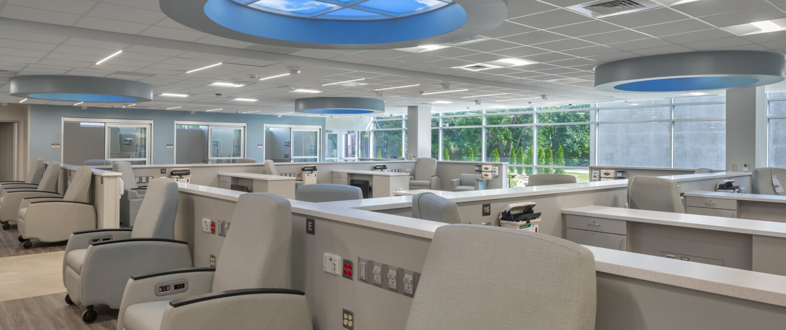 Medical office with rows of chairs with countertops and sinks with round lighting with blue glow