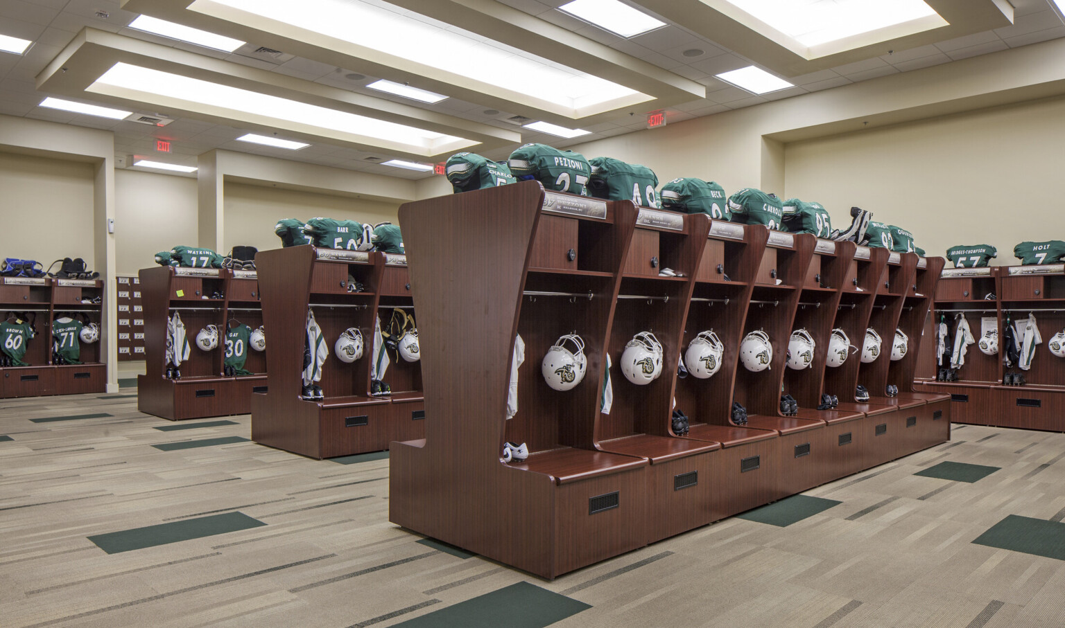 Wood lockers line the room and form rows through the center. Space for hung equipment behind bench and above