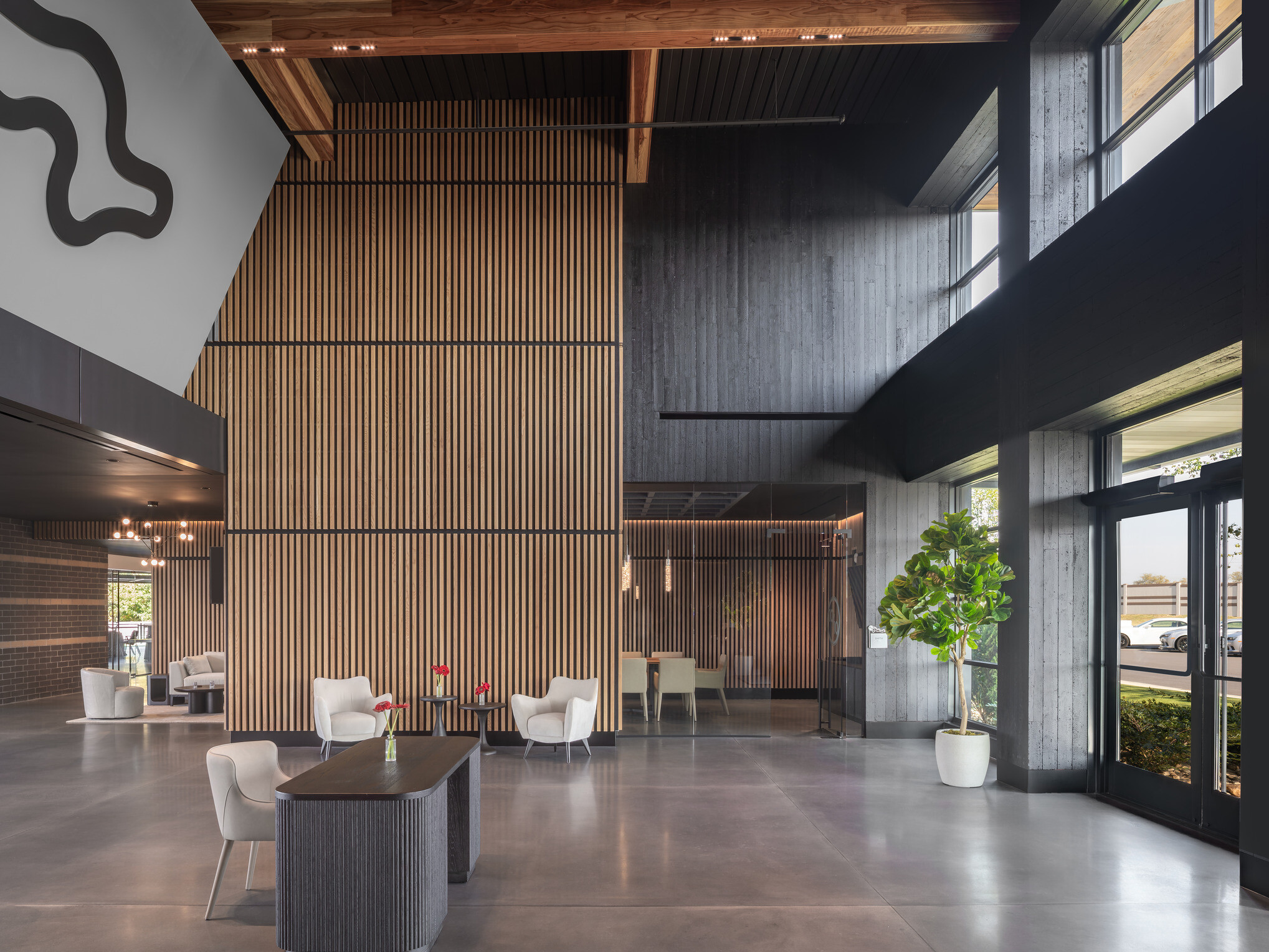 modern lobby and lounge space; entry way floor to ceiling glass with doors open