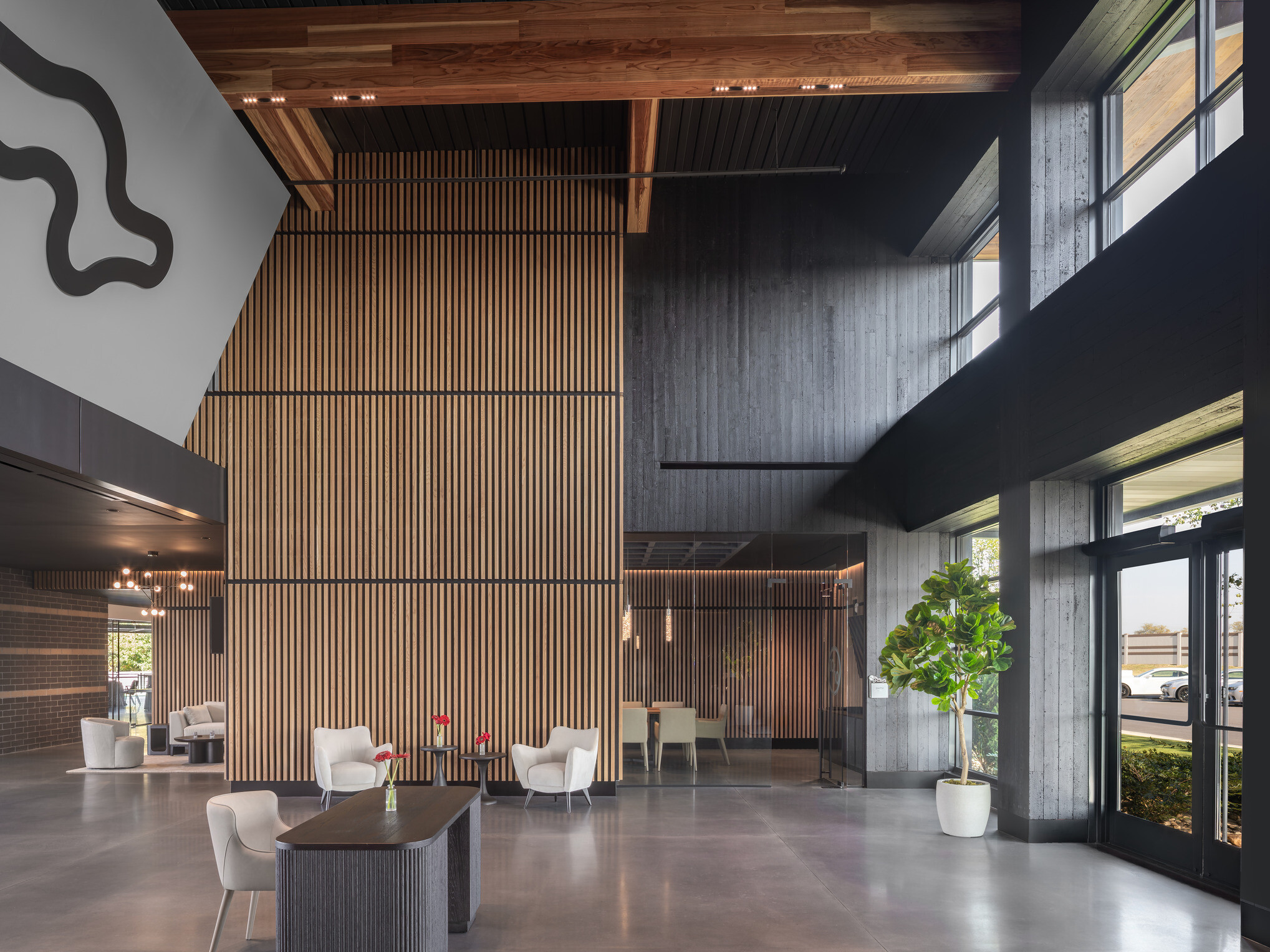 modern lobby and lounge space; entry way floor to ceiling glass with doors open