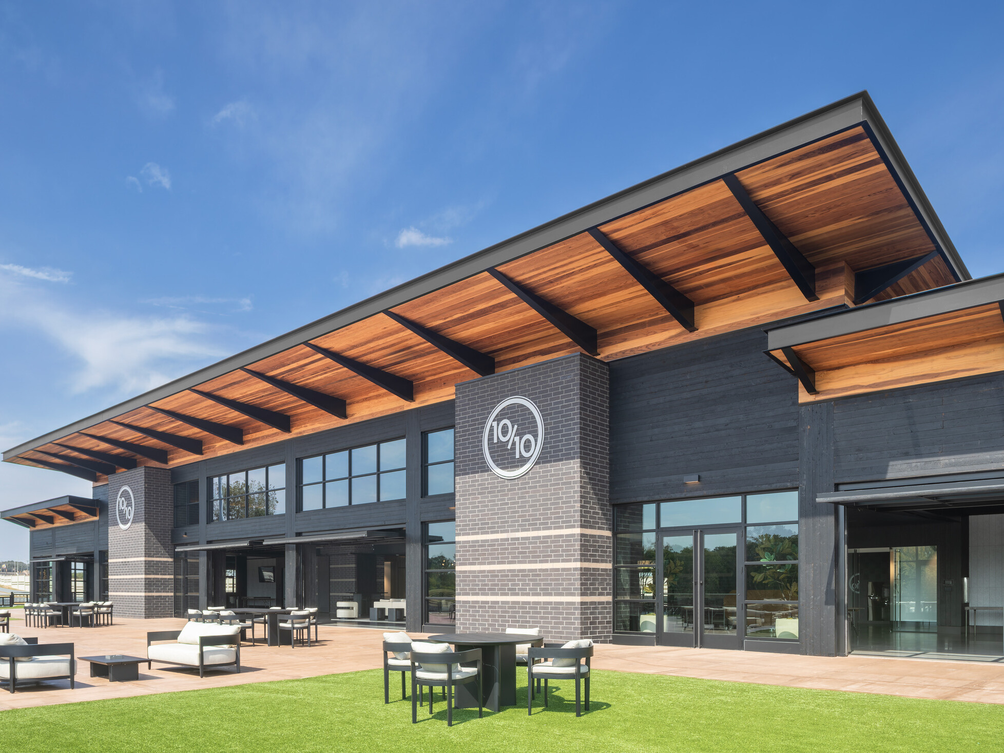exterior of Ten Tenths Clubhouse; black exterior brick with a mass timber awning