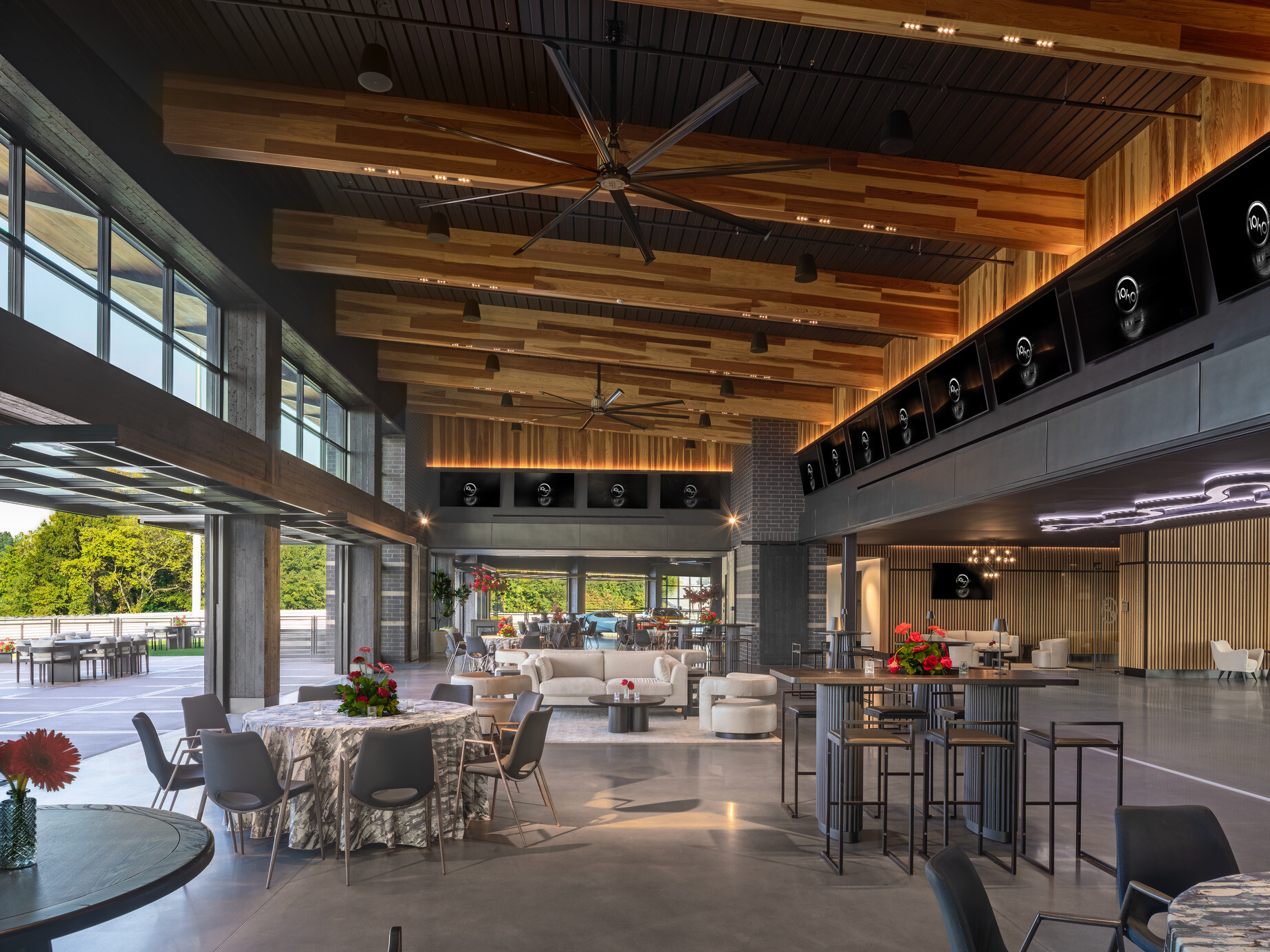 open concept lounge space with exposed wood ceiling and floor to ceiling indoor outdoor space