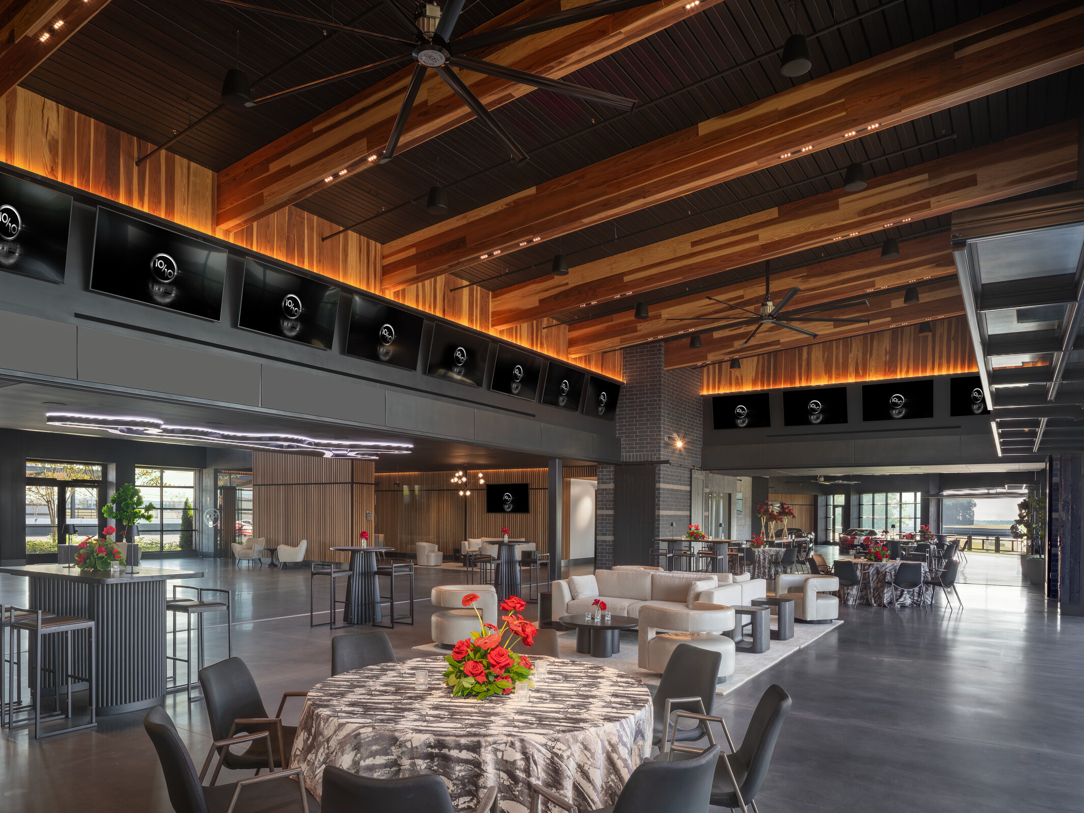 open concept lounge space with modular seating facing floor to ceiling windows and entries