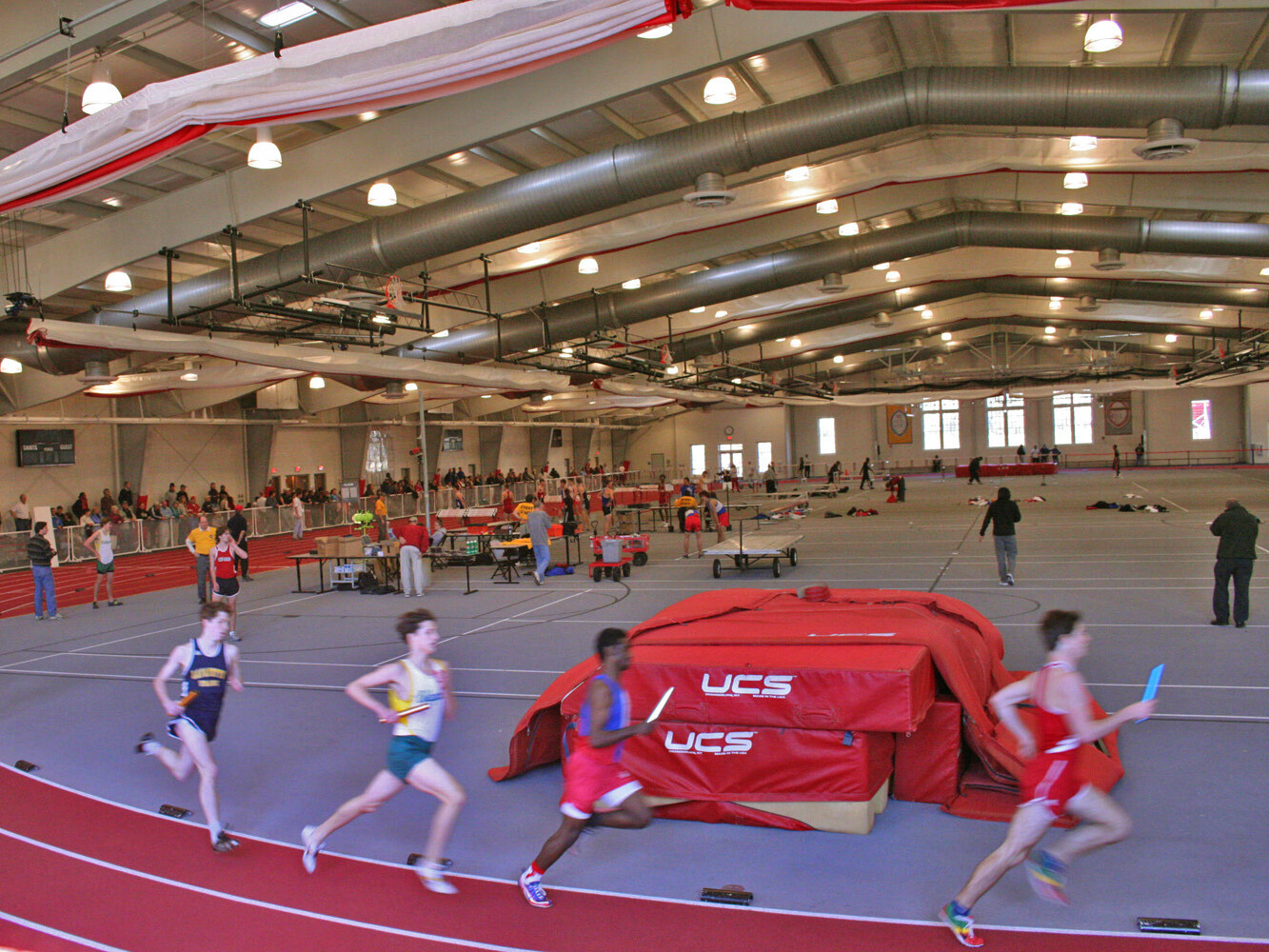 Indoor running track with people running on red lanes
