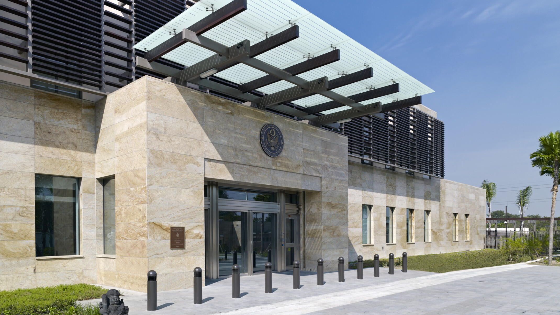 Exterior entrance of U.S. Consulate General, Surabaya, Indonesia. Off white tile exterior with metal louvered awnings