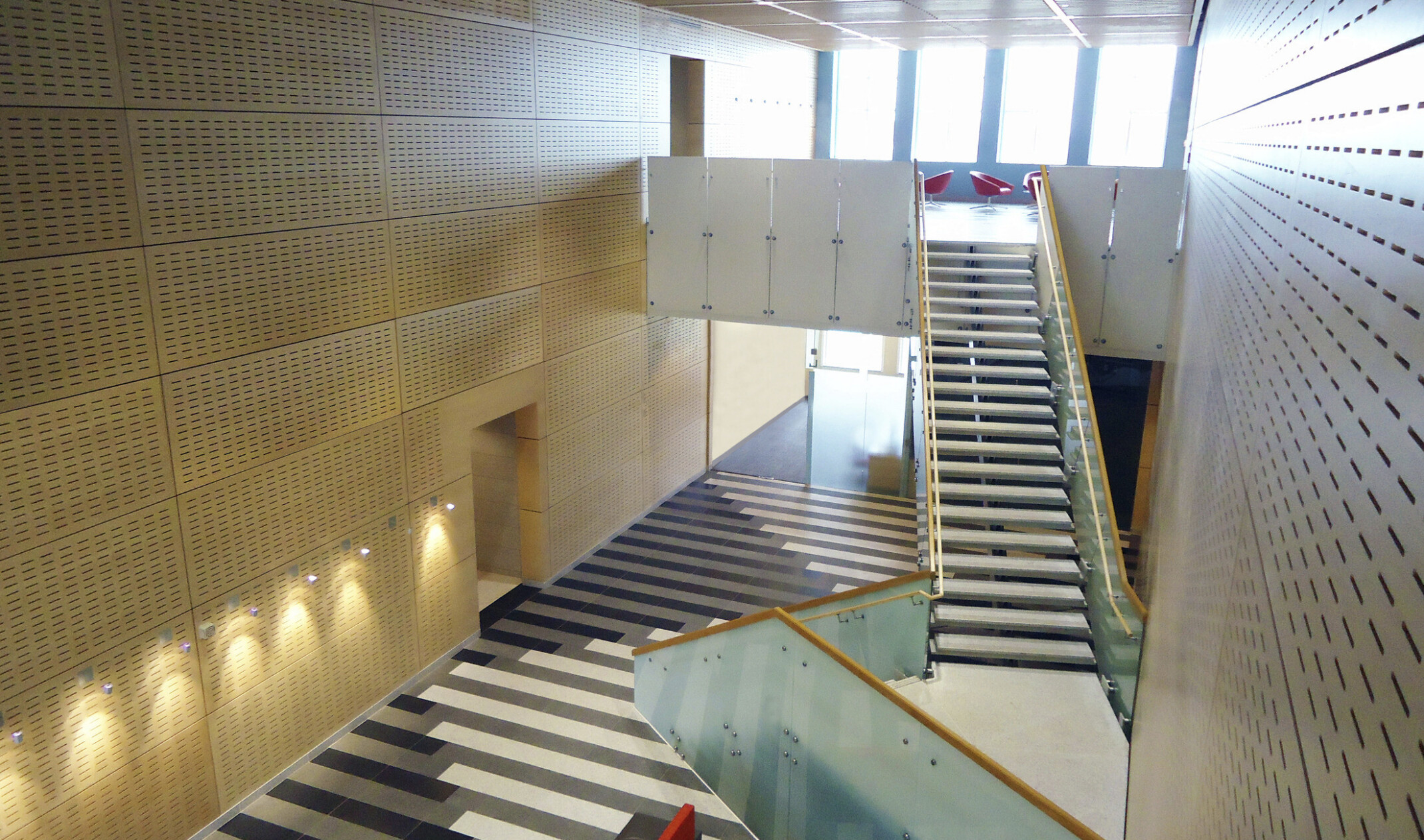 sunlit Indoor stairwell, glass, metal and concrete, clerestory windows, geometric patterned flooring