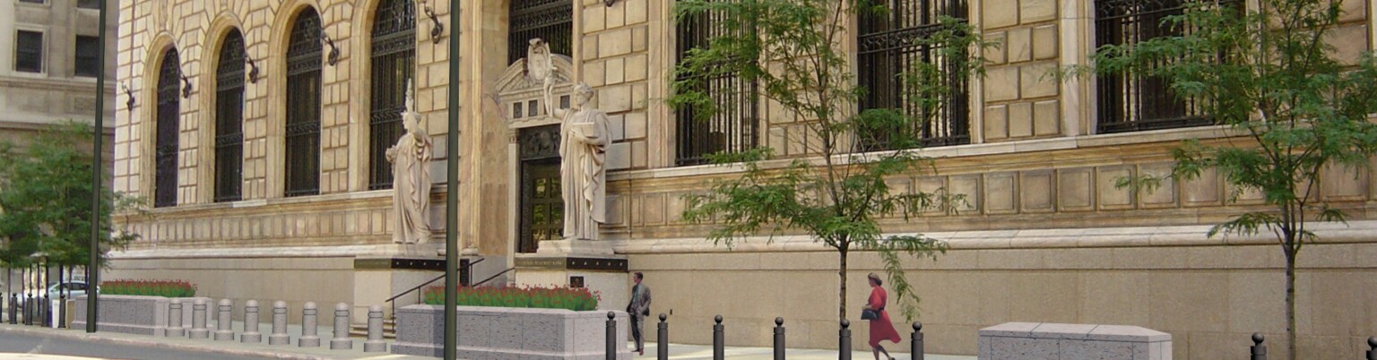 angled exterior view of a Classical-style federal bank with pink Georgia marble façade and arched stone windows inset with ornate iron grilles.