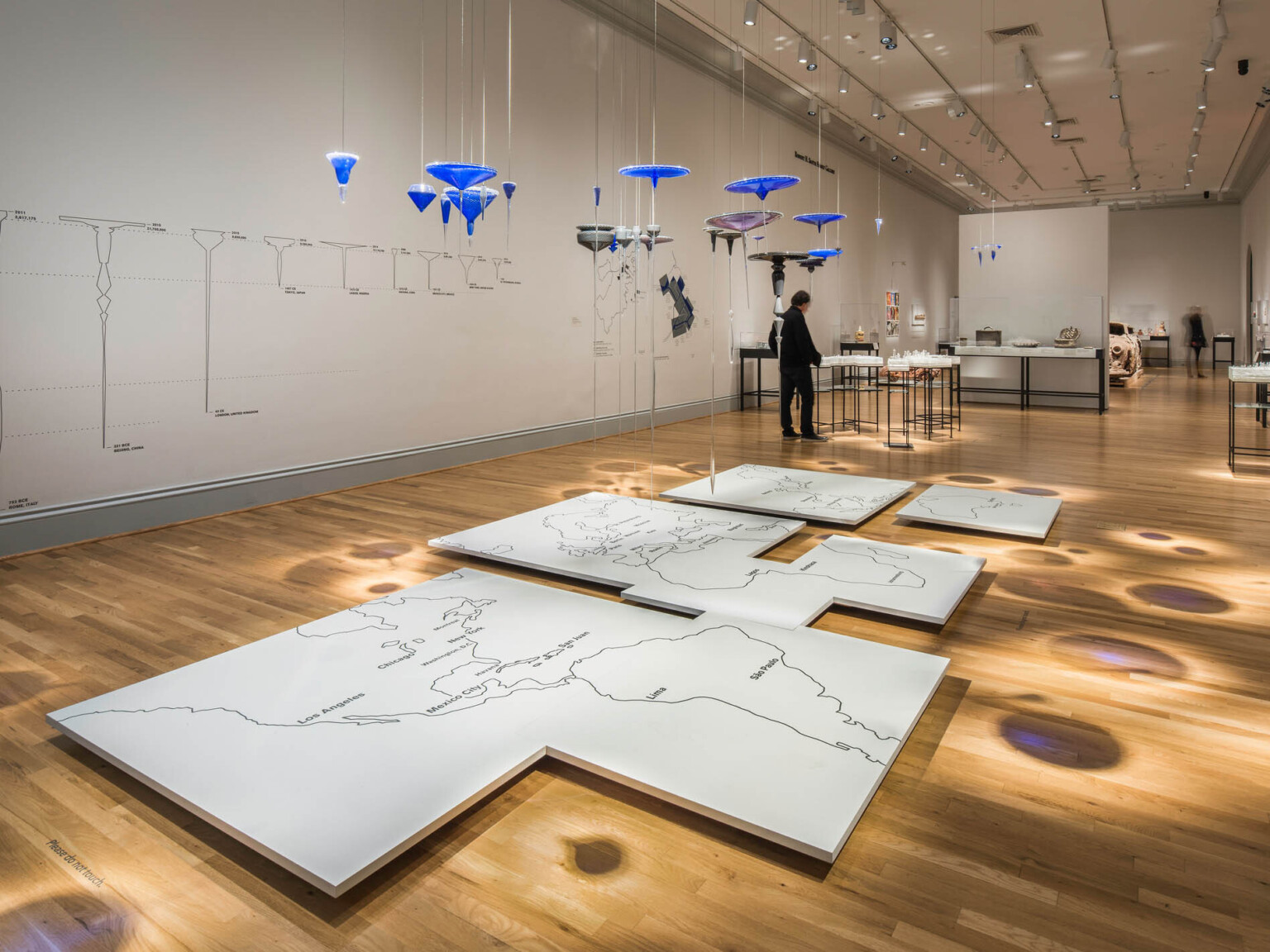 White gallery with wood flooring displays multimedia art