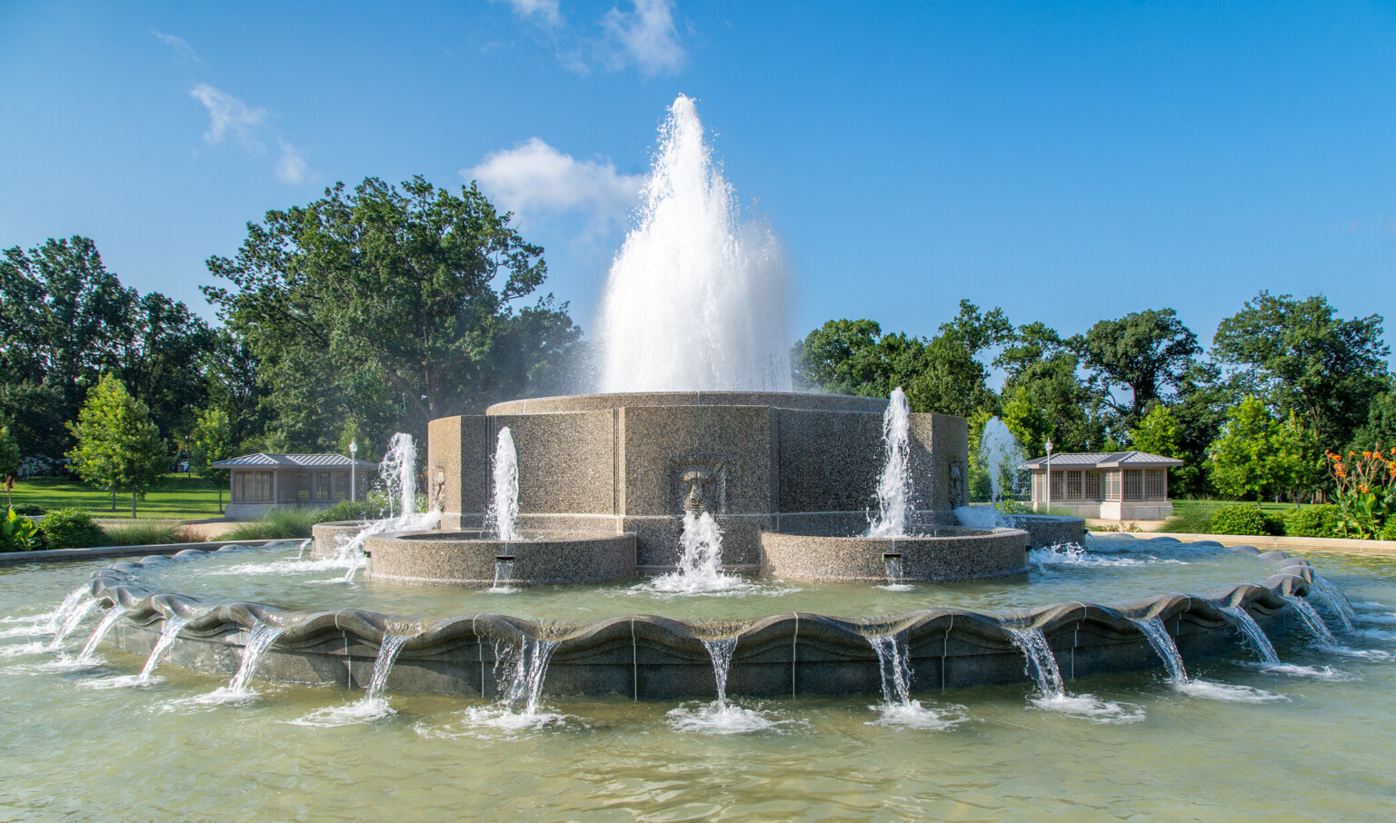 A close-up of a circular fountain featuring marble stone work and decorative elements