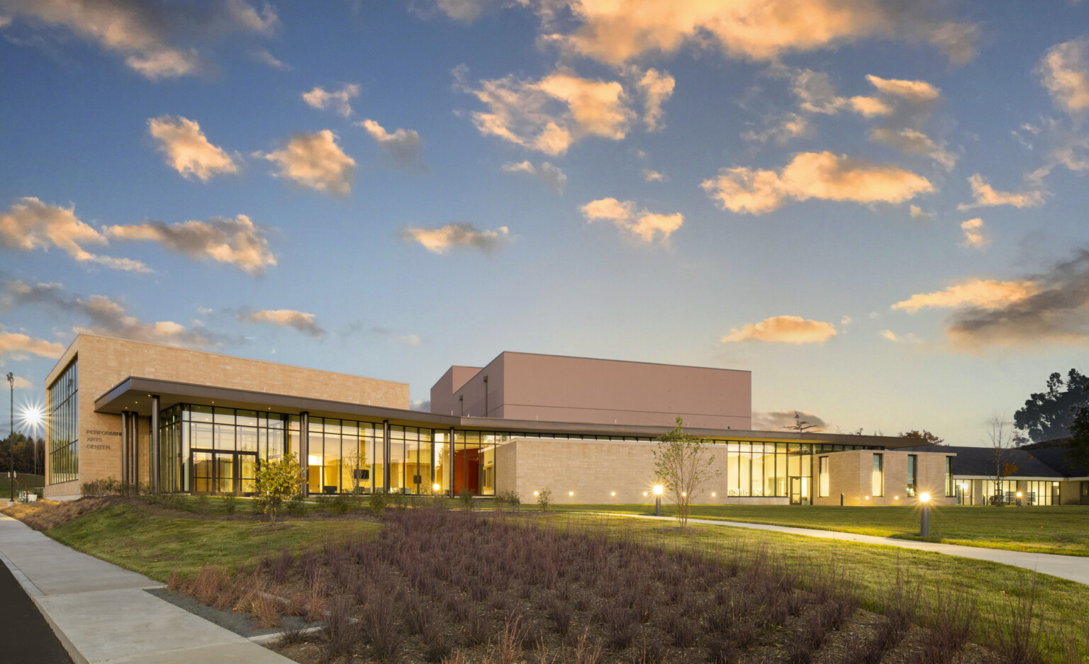 Exterior of the performing arts center at Garrett College, showcasing modern architecture at nightfall with subtle lighting