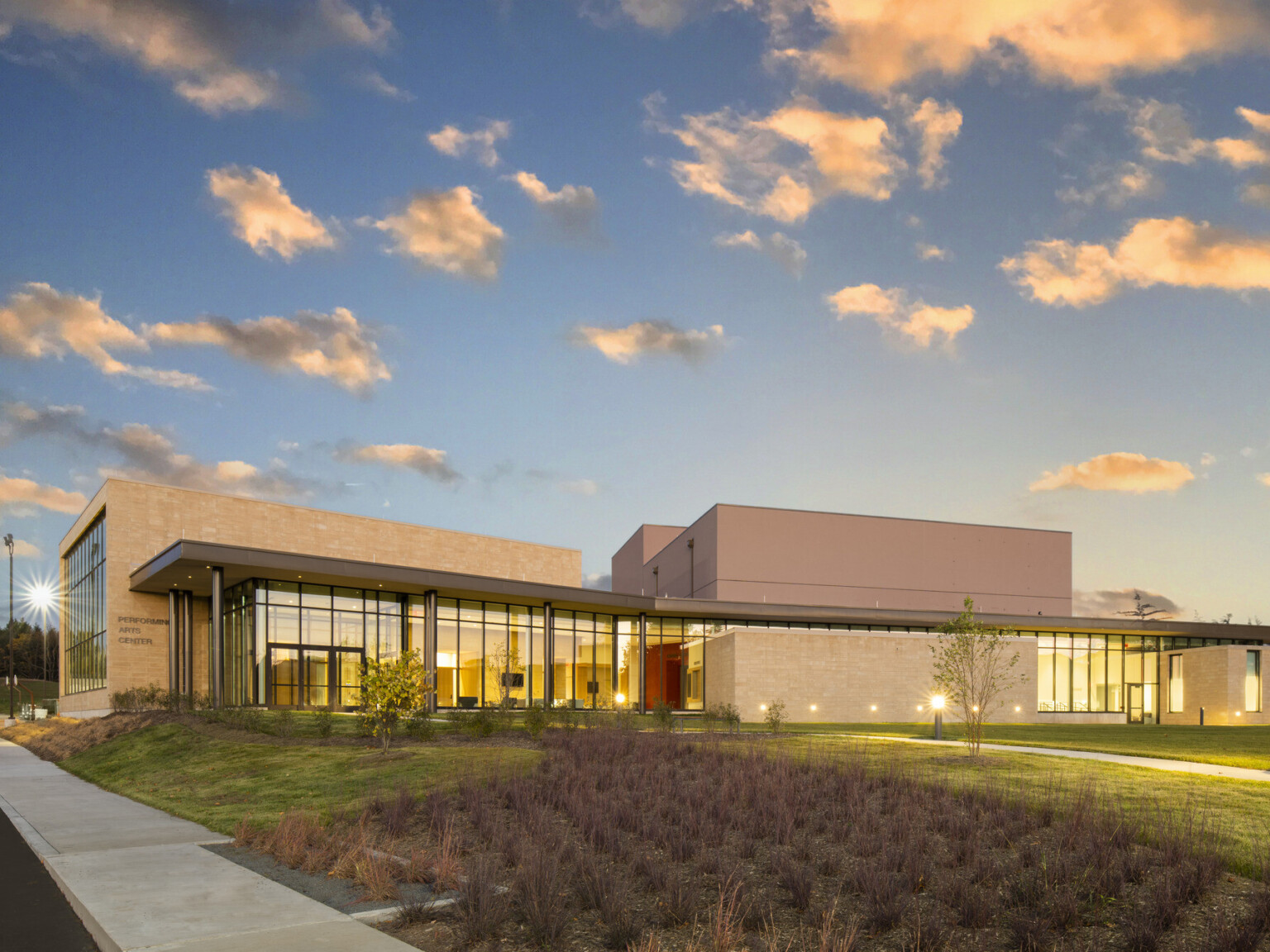 Exterior of the performing arts center at Garrett College, showcasing modern architecture at nightfall with subtle lighting