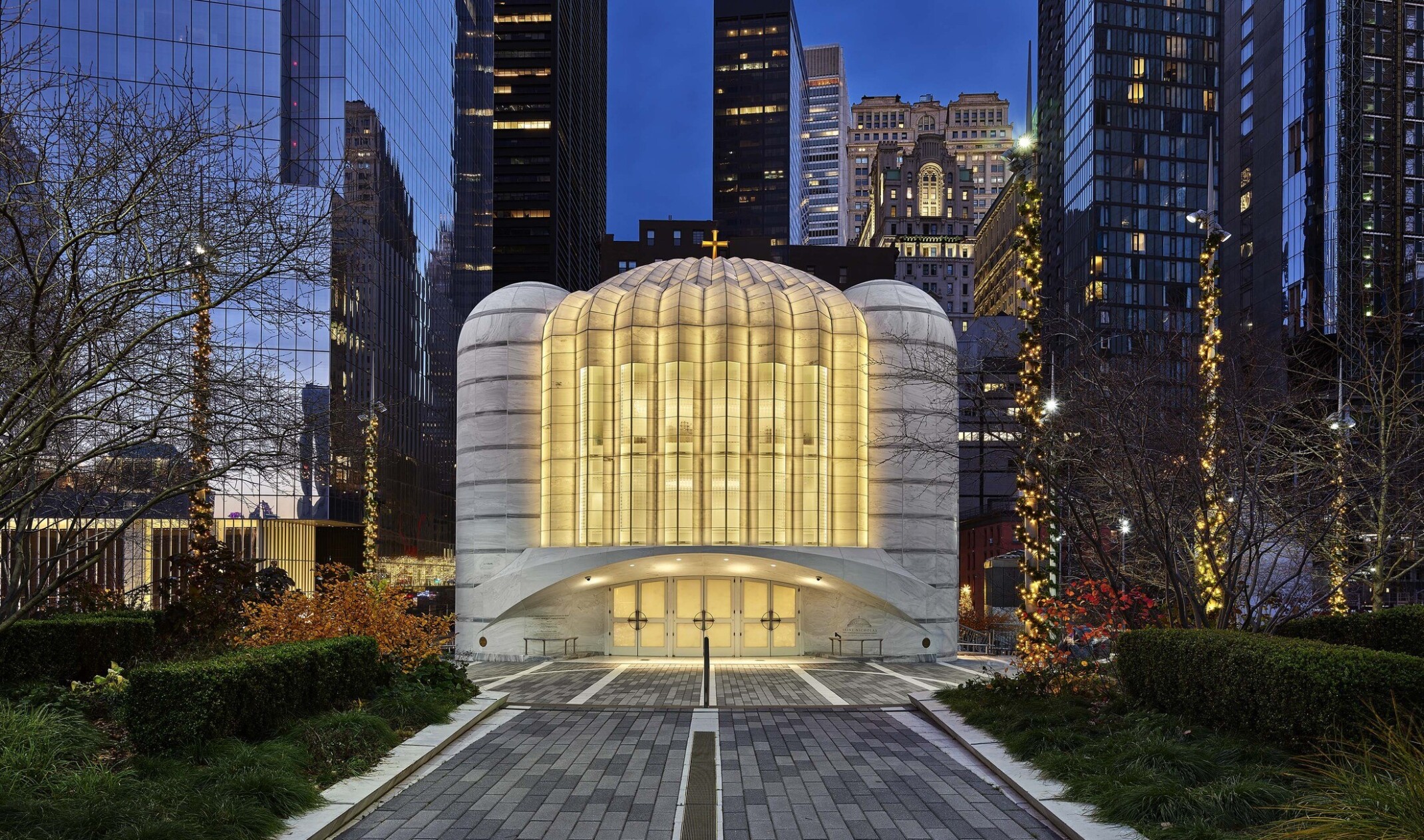 Saint Nicholas Greek Orthodox Church illuminated in the evening, a white and rounded building at the new World Trade Center in New York City