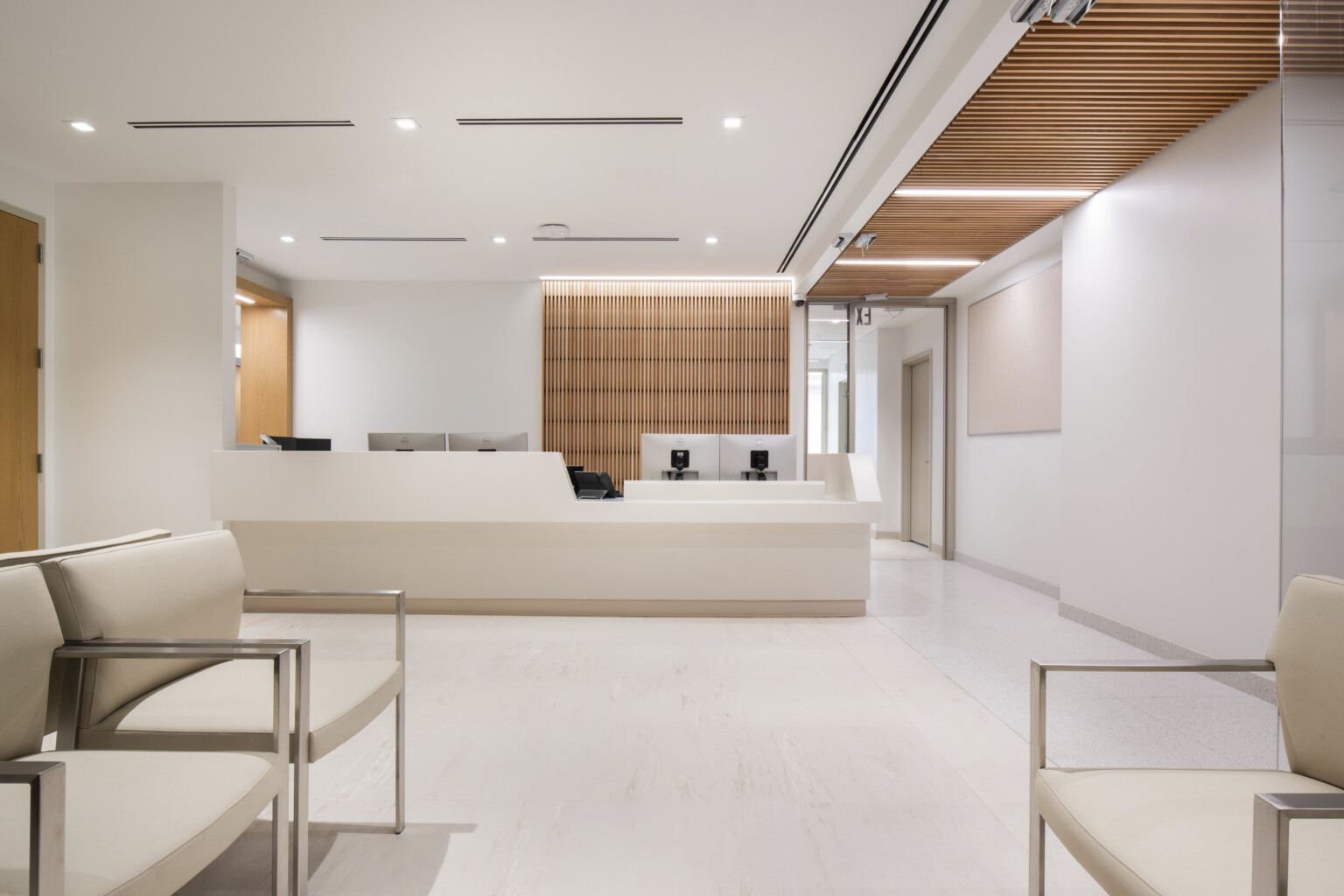 reception area for Mt. Sinai cardiology, soothing cream colors for walls, flooring and ceiling, skylights provide a serene connection to nature, two primary wayfinding devices – exterior windows along the corridor and natural wood - help patients understand their current location and how to navigate to their destination