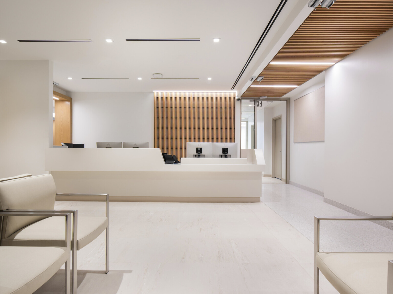 reception area for Mt. Sinai cardiology, soothing cream colors for walls, flooring and ceiling, skylights provide a serene connection to nature, two primary wayfinding devices – exterior windows along the corridor and natural wood - help patients understand their current location and how to navigate to their destination