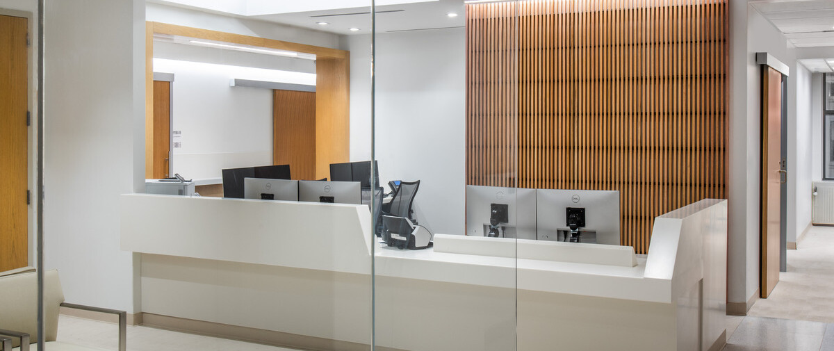Medical office desk area with a white desk and wooden accents.