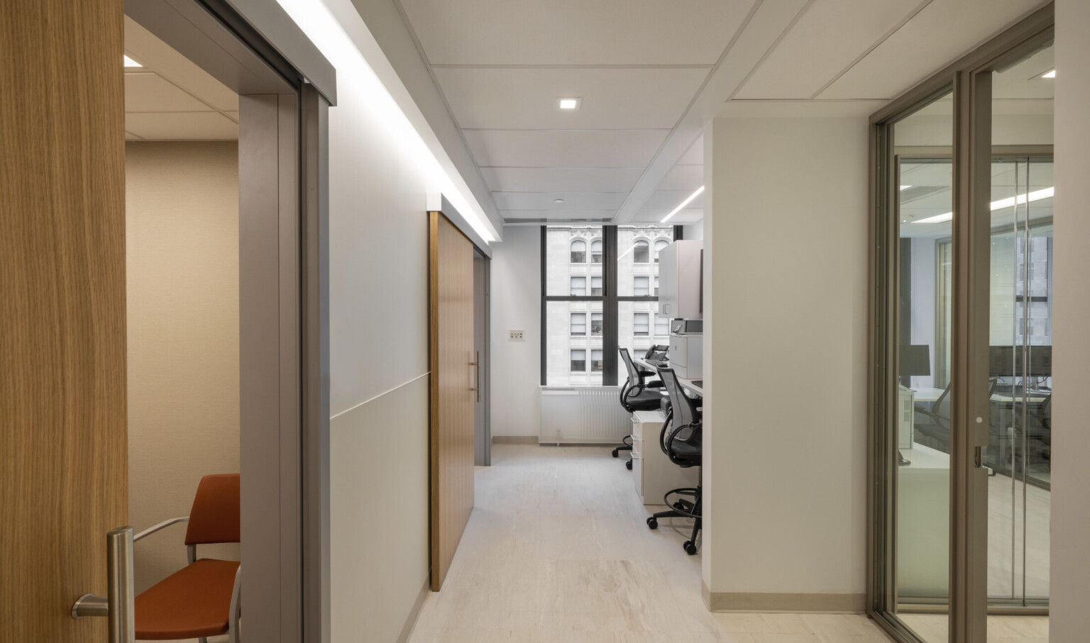 champagne–finished storefront with full-height glazing to allow light to penetrate in the corridors, a view toward the outside in public corridors, natural wood was employed as a wayfinding device to help patients find their way on their journey through the facility