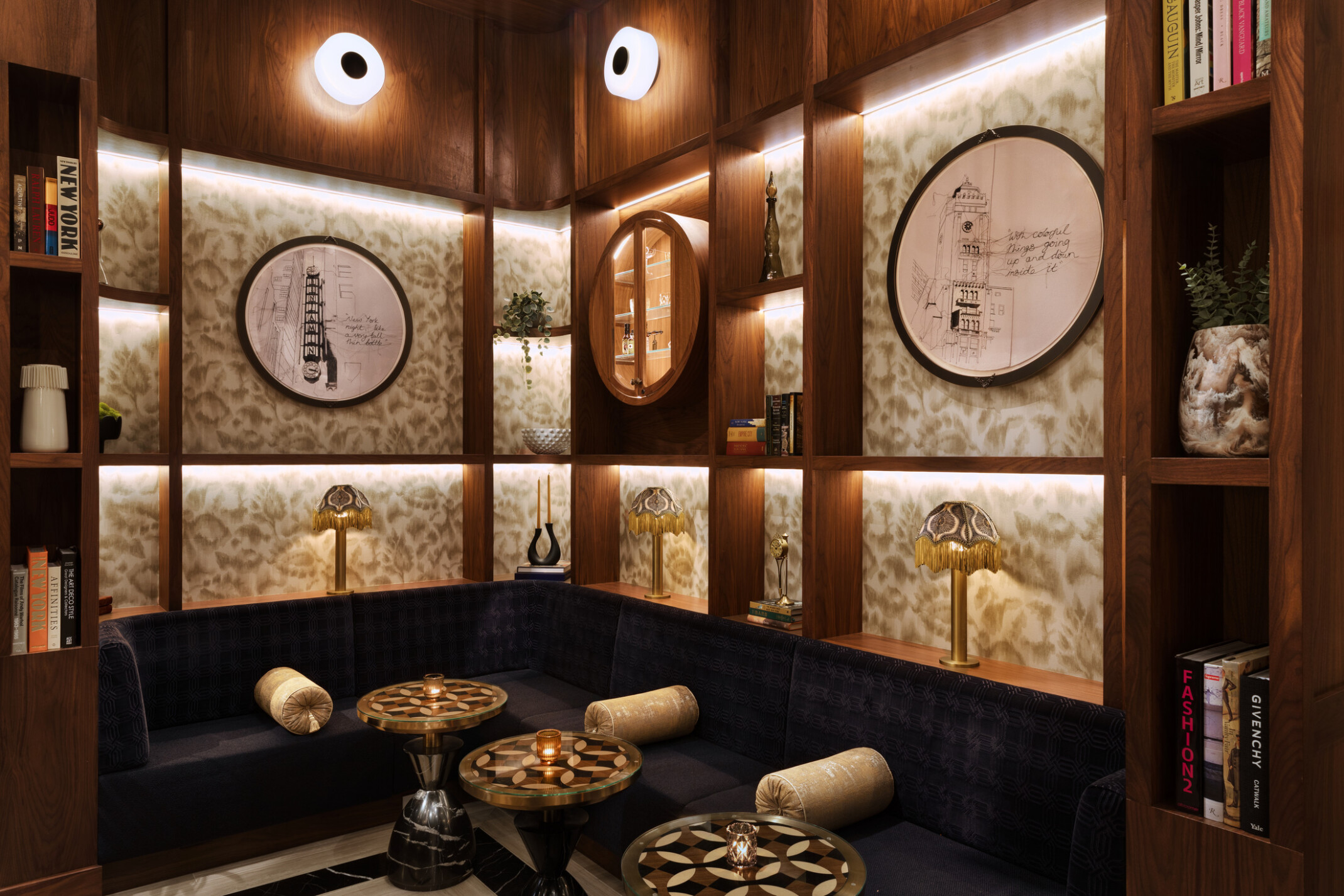 Modern seating area with black velvet bench seating below wooden shelves built into the wall display artwork and other pieces