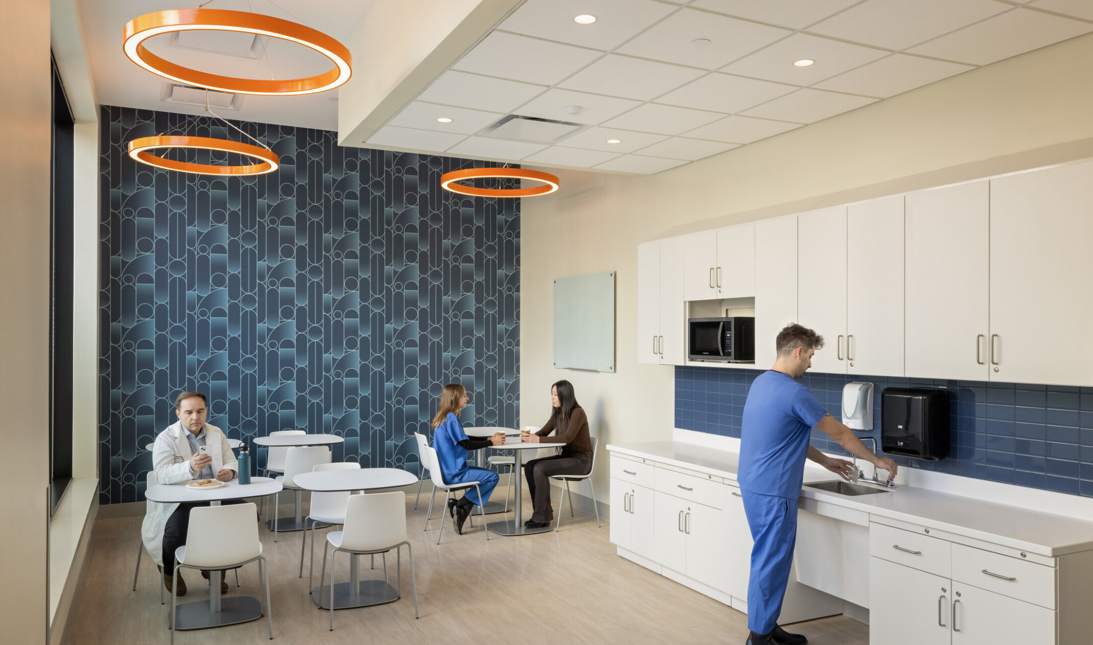 modern medical staff room with statement blue patternal background wall; countertop and table seating throughout
