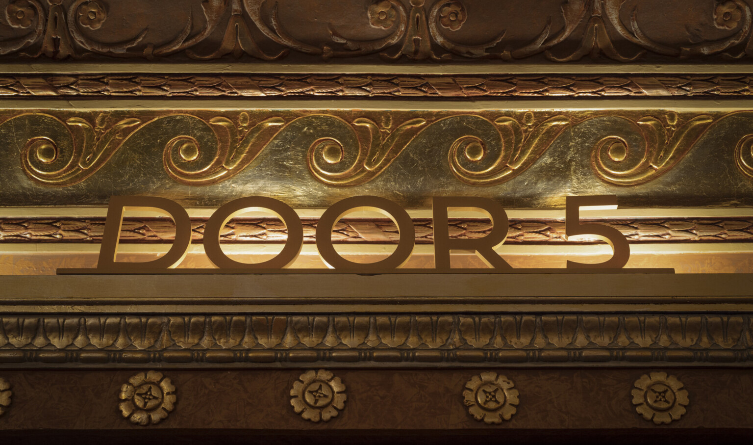"door 5" sign in a gold decorated theater