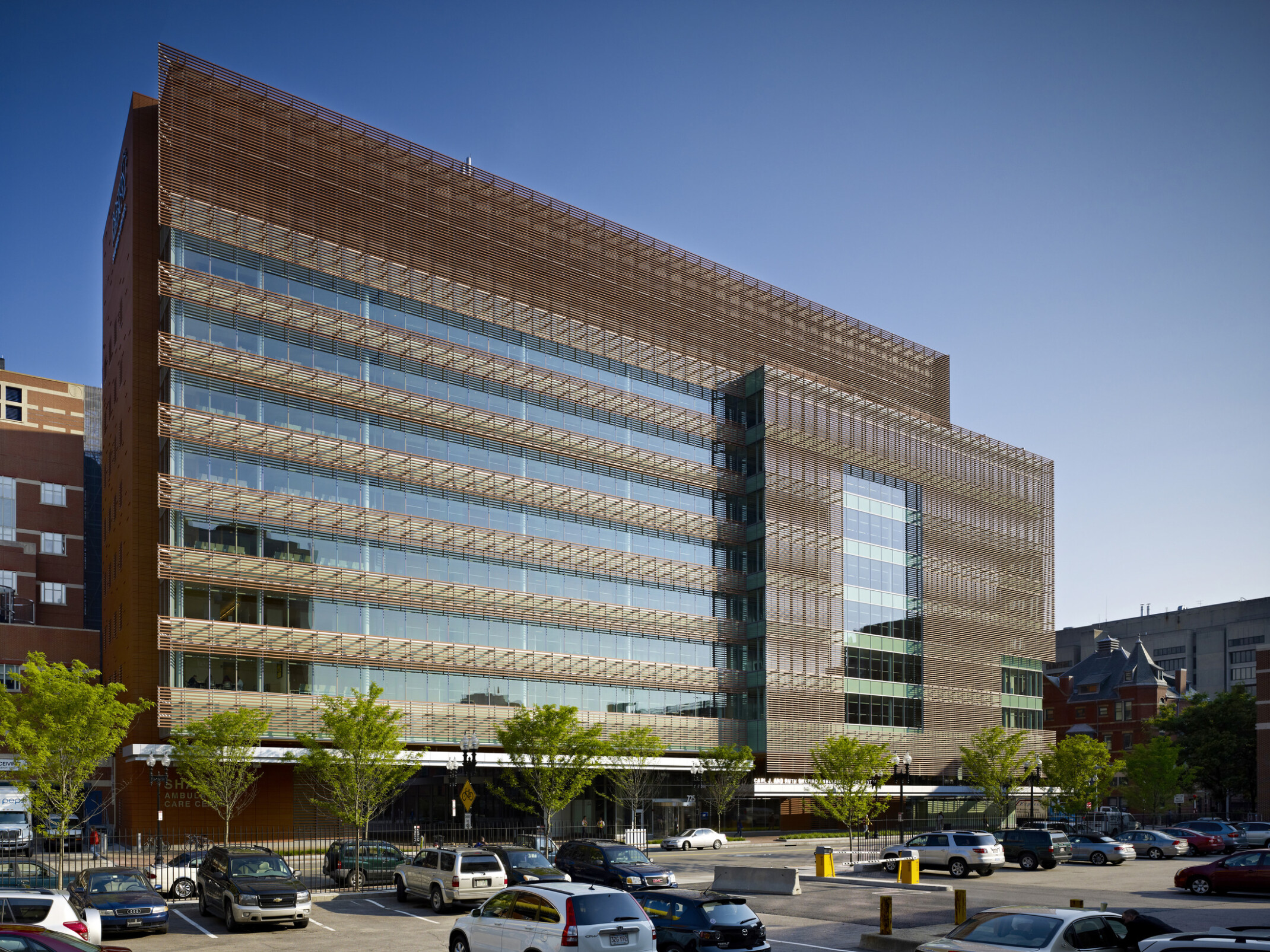 A modern multi-story medical building with a glass and metal mesh façade.