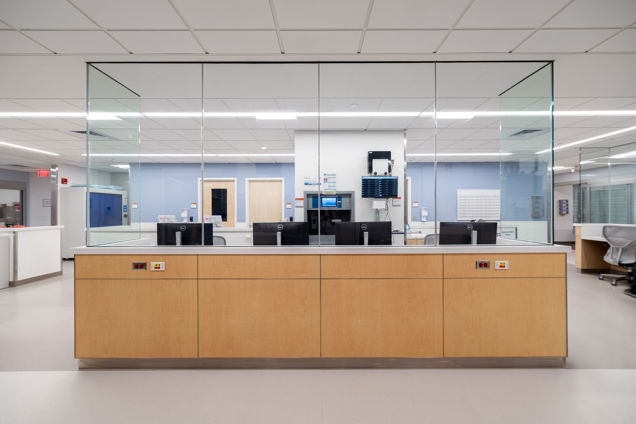 modern hospital nurses station; bright wood with glass barriers