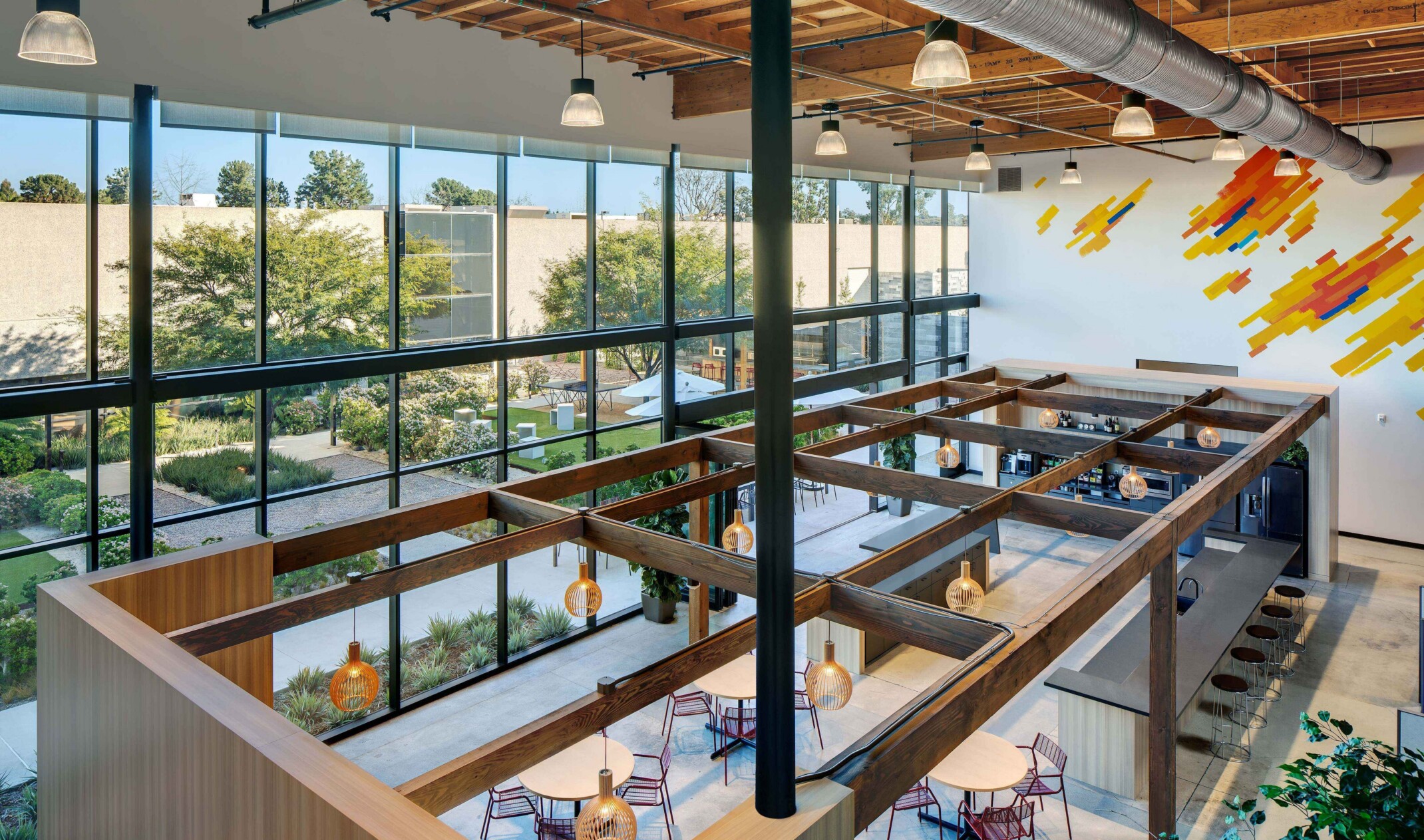 top floor looking down into an office reception space; modern features highlighted by floor to ceiling windows