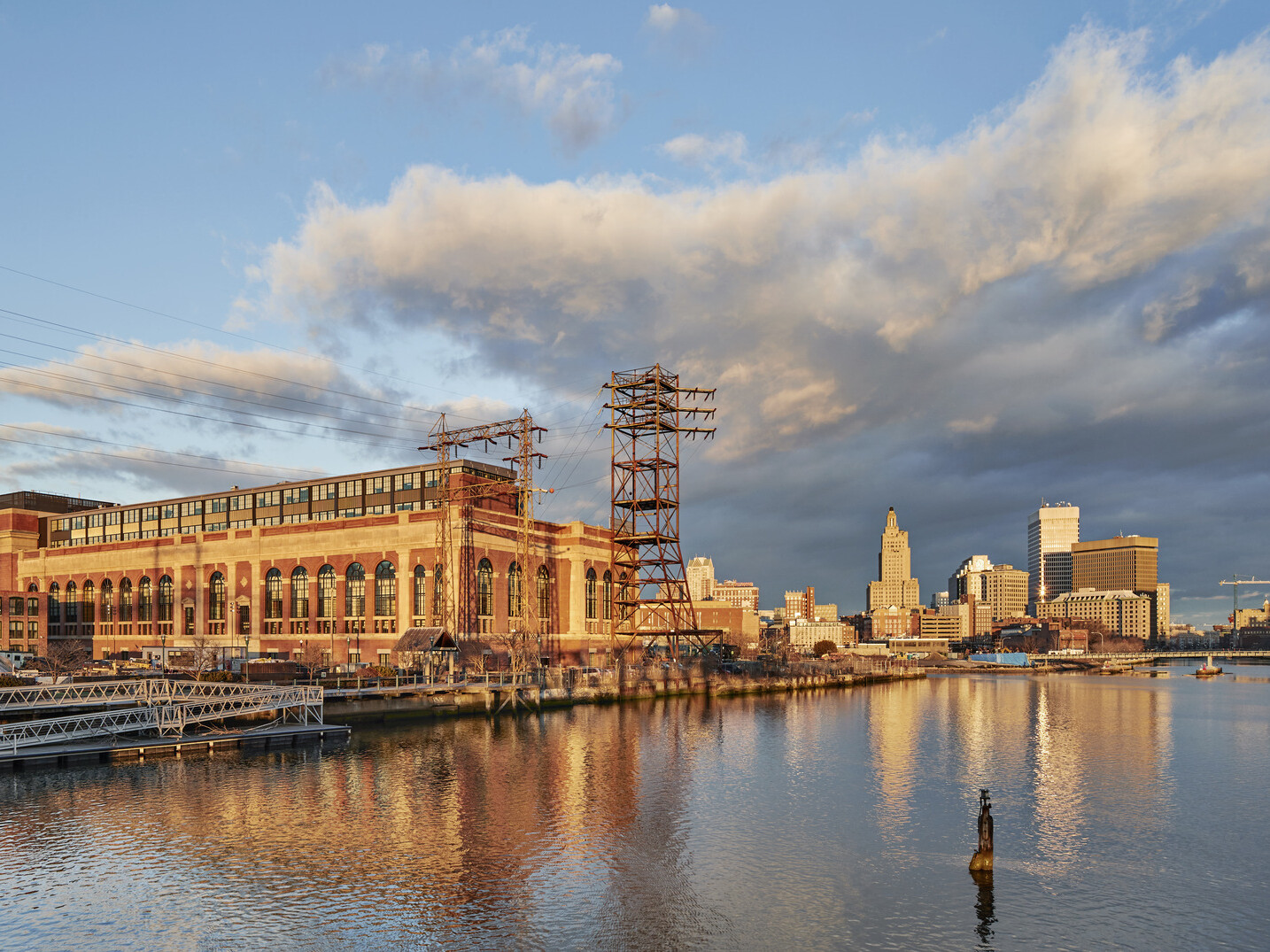 River view of South Street Landing in Providence, RI; adaptive reuse of an old power station into medical training facility; large building with older facade and power lines surrounding