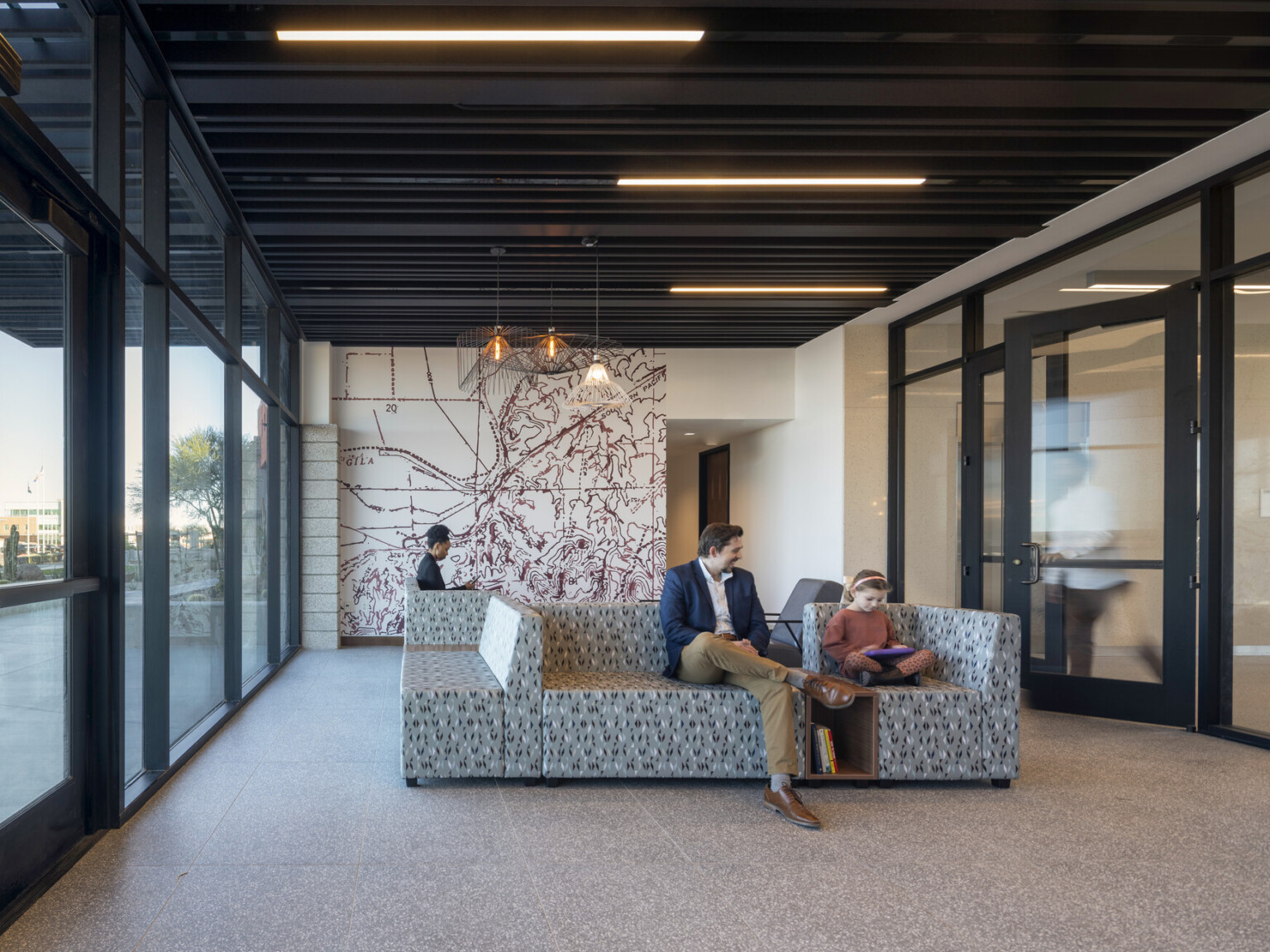 Lobby entrance with glass looking out to the desert, mural on far wall, modern wire geometric shade son pendant lights