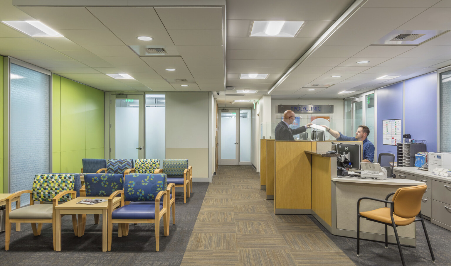 incorporating branding in the color scheme & signage create a sense of security through continuity for visiting patients, a lime green wall, blue and green patterned upholstery, light woods, taupe carpet