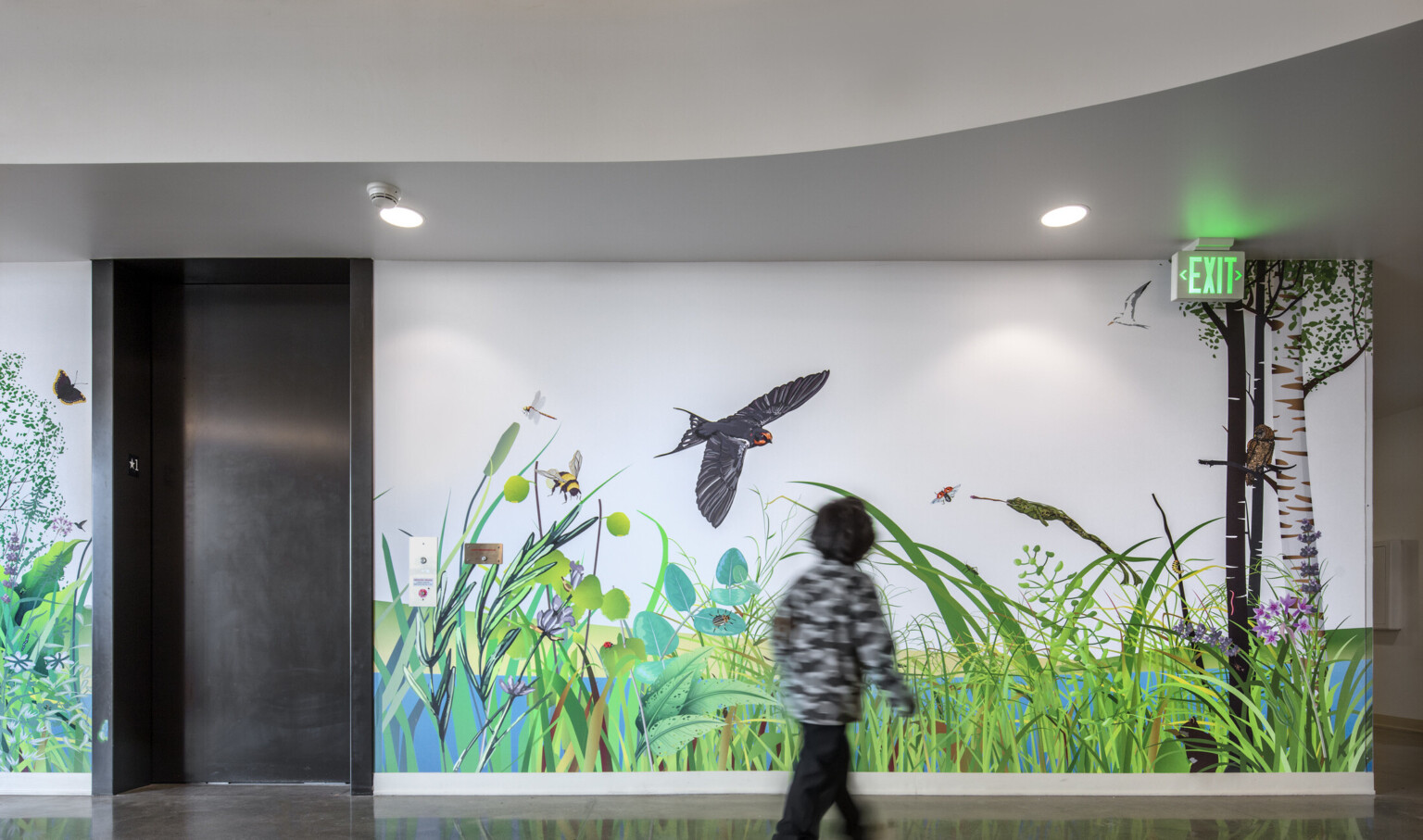Closeup of child looking at mural next to elevator