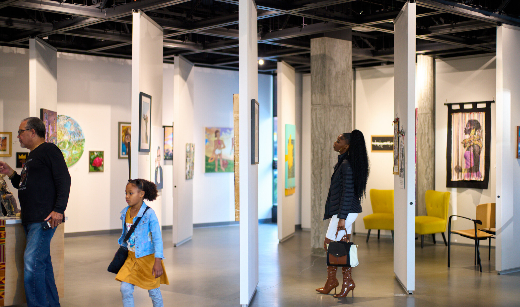 people looking at art on modular wall panels; open industrial modern space