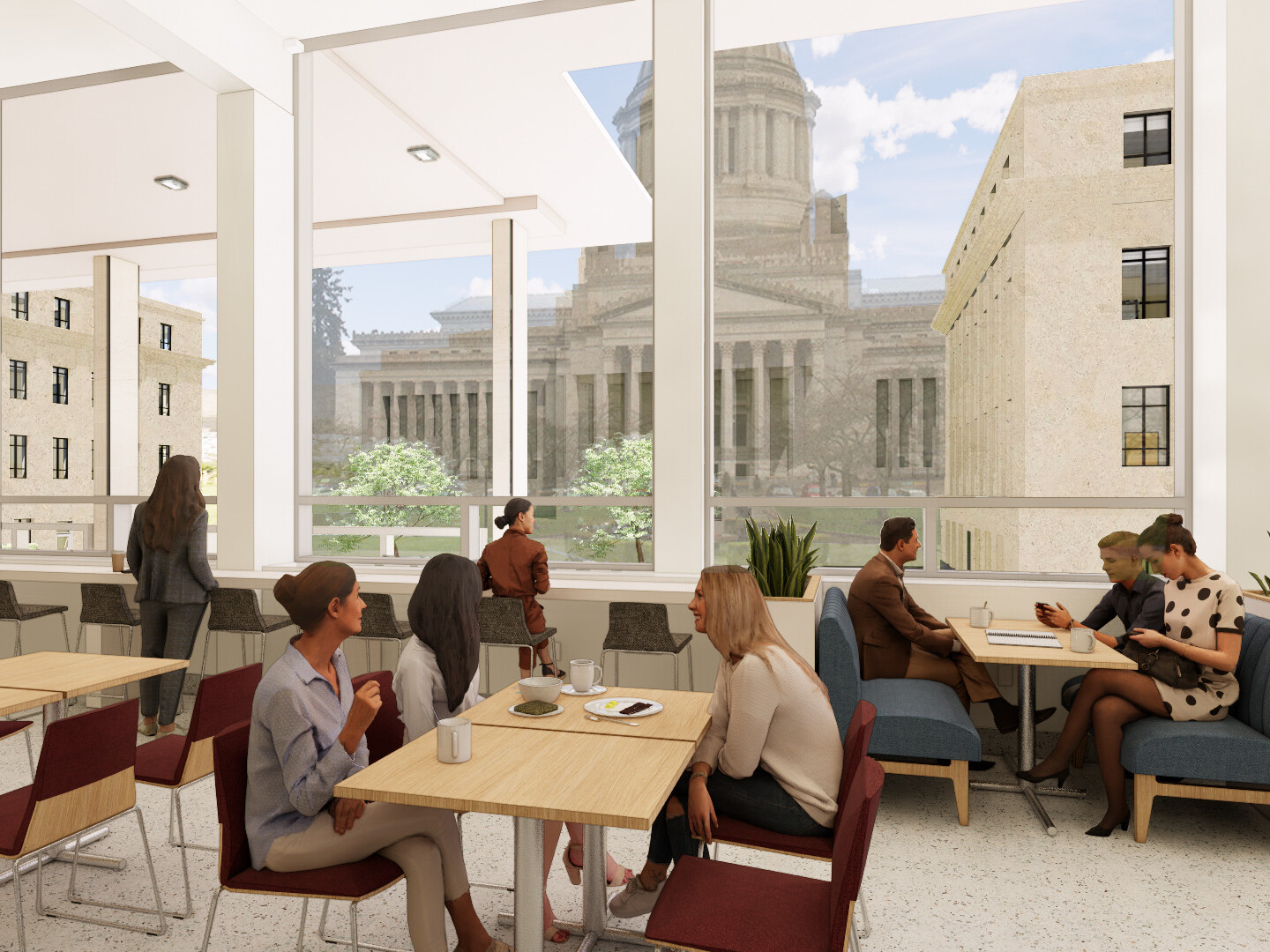Office cafeteria filled with tables and chairs with large glass windows overlooking multi story buildings