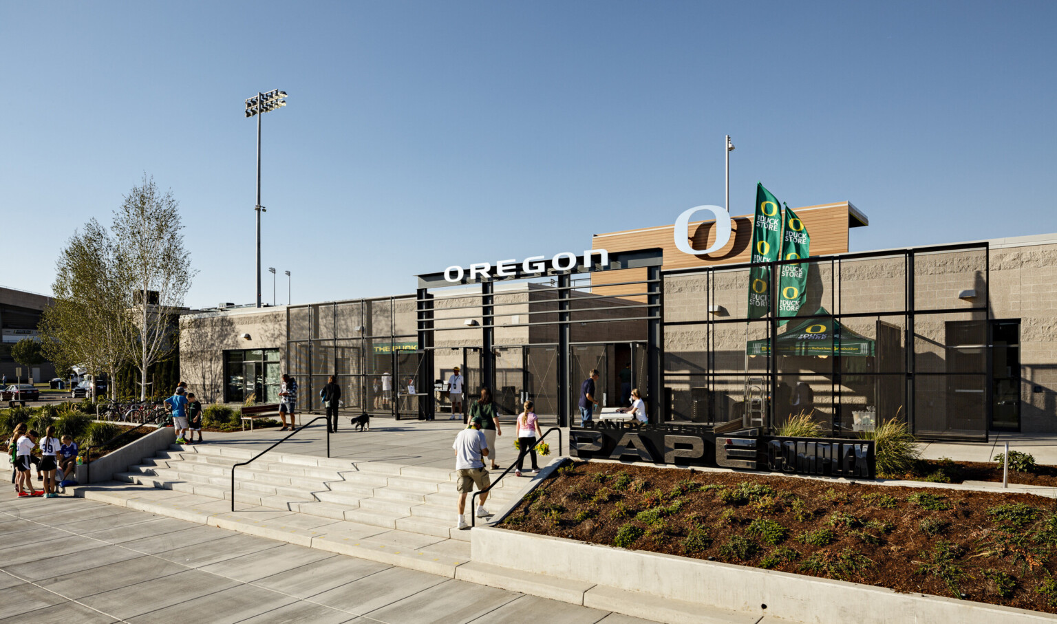 Papé Field entrance, 1 story concrete building with black gates surrounding exterior concession stands. Oregon logo at center