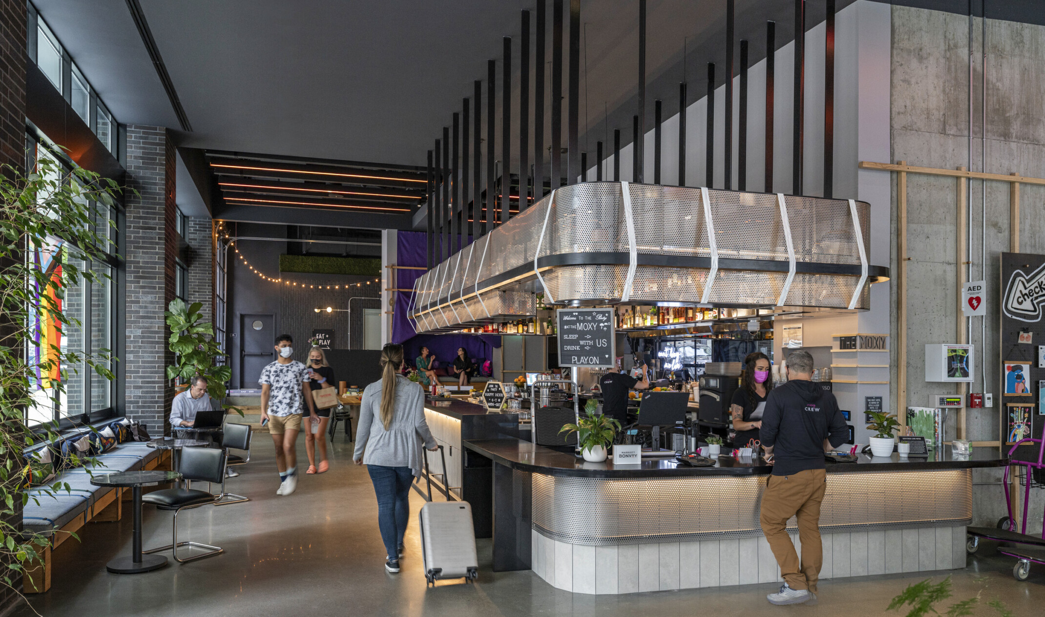 check-in counter with adjacent banquette seating and movable tables