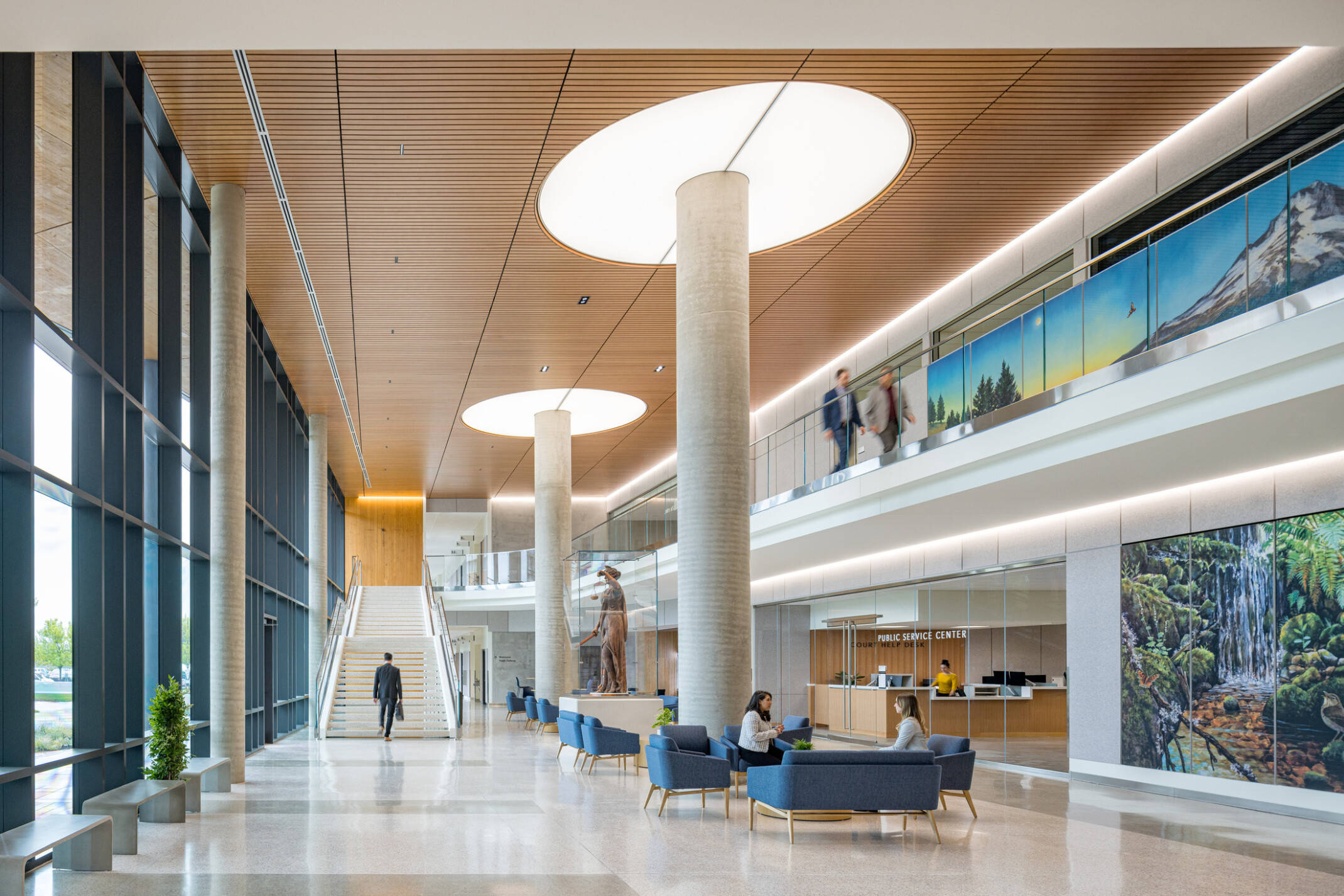interior of Clackamas County Courthouse; large open concept lobby space with a varied seating and double height space; staircase at the back wall