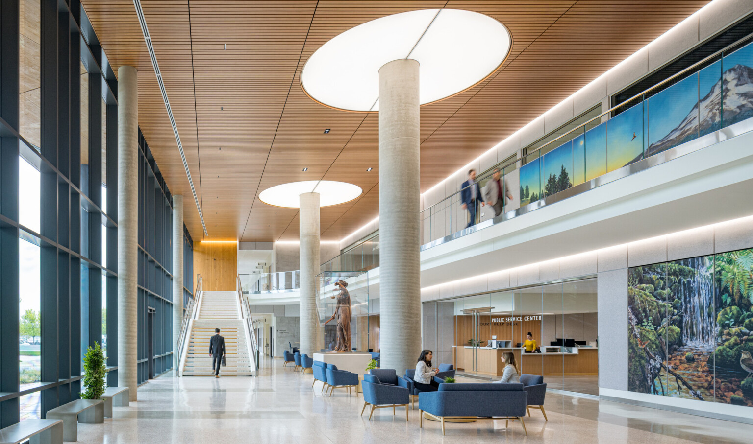 interior of Clackamas County Courthouse; large open concept lobby space with a varied seating and double height space; staircase at the back wall