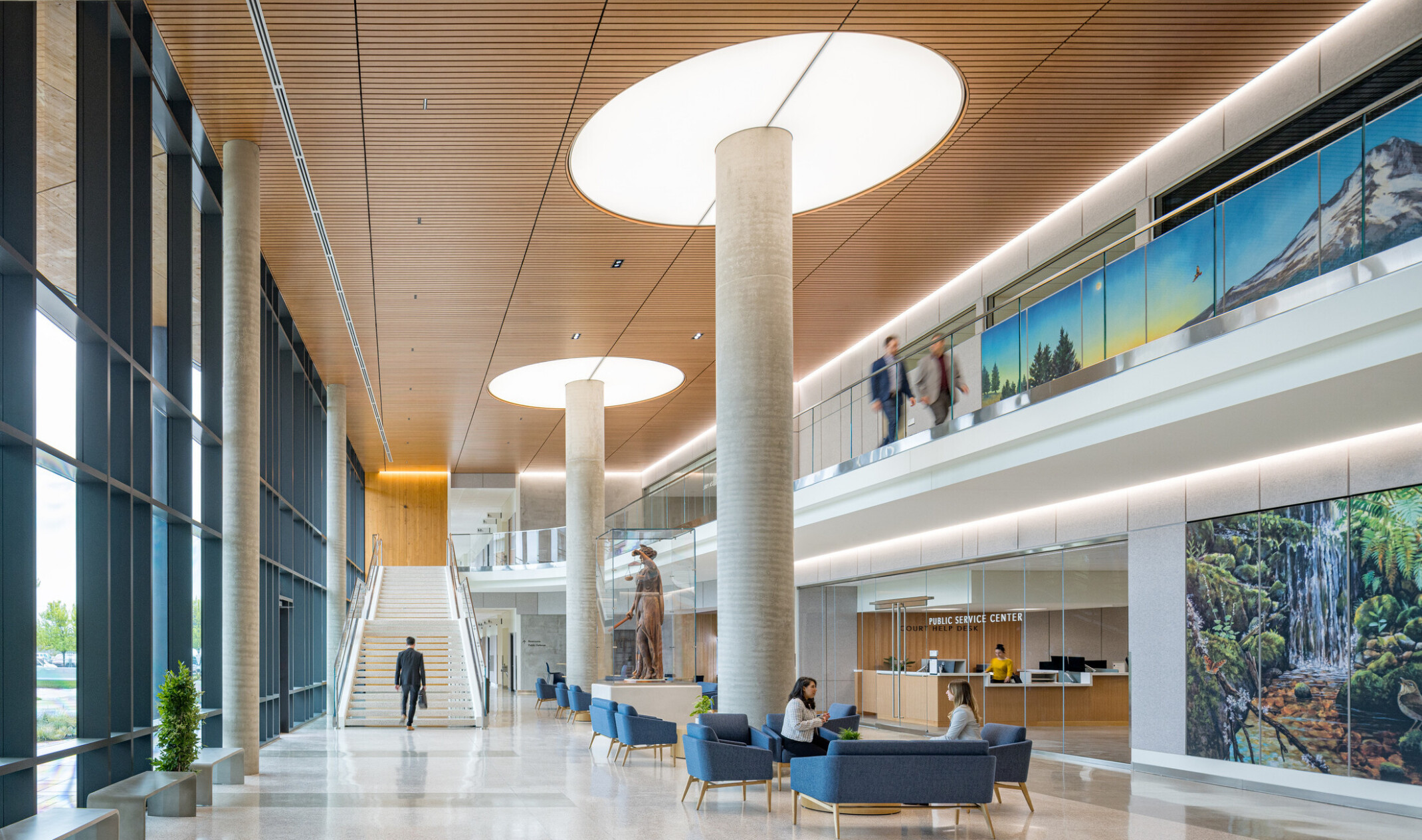interior of Clackamas County Courthouse; large open concept lobby space with a varied seating and double height space; staircase at the back wall