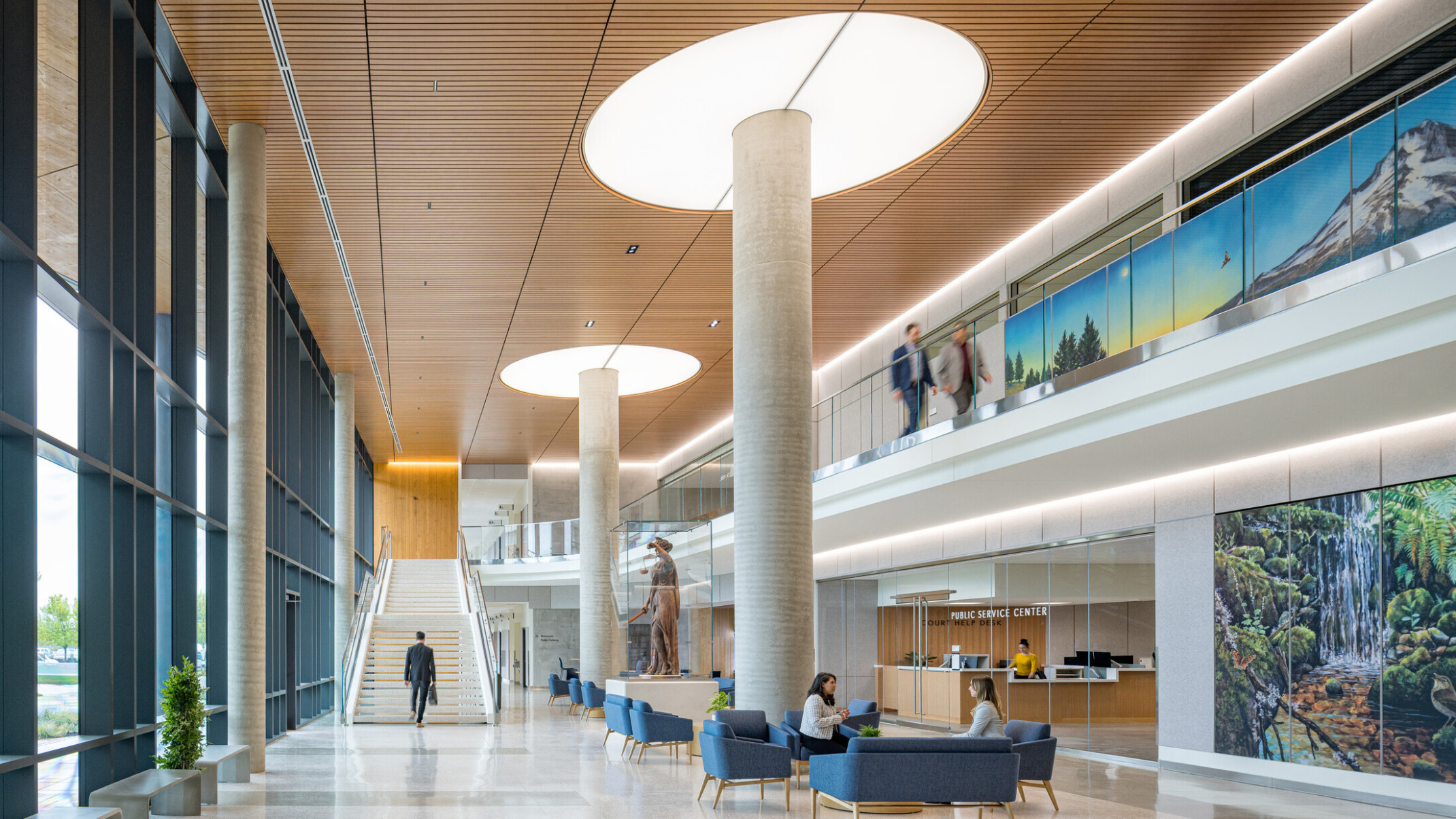 interior of Clackamas County Courthouse; large open concept lobby space with a varied seating and double height space; staircase at the back wall