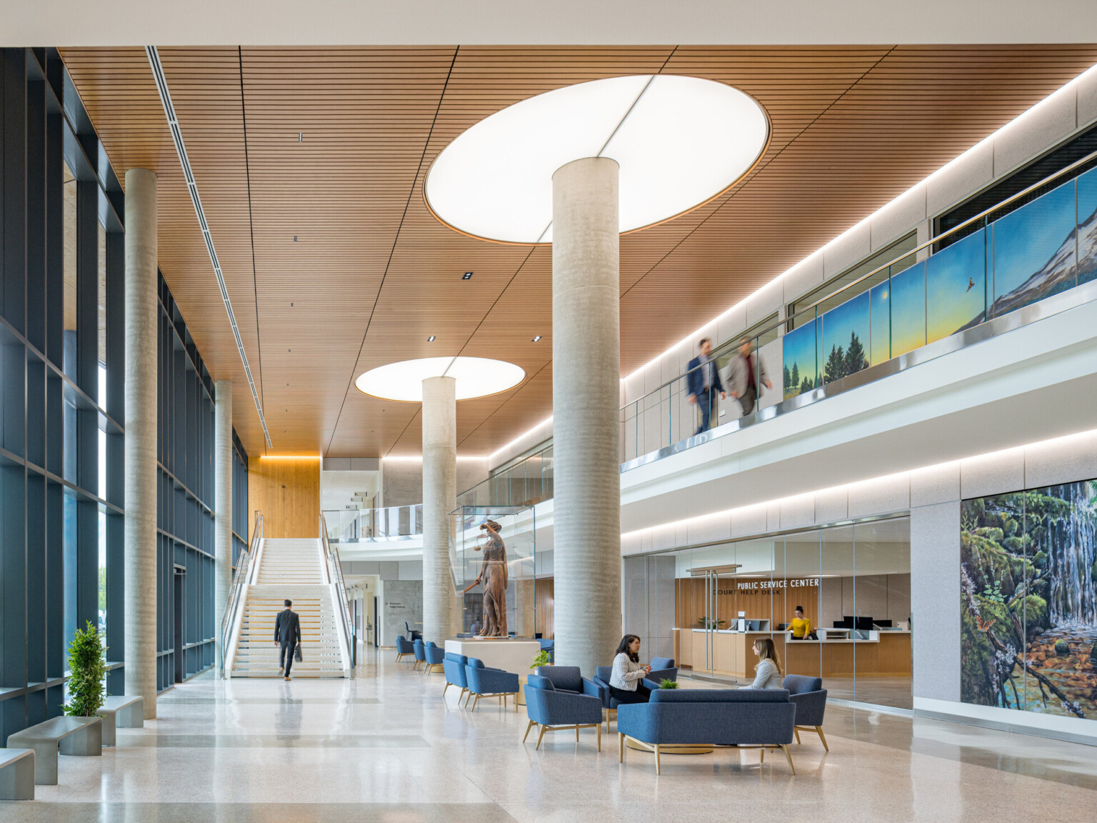 interior of Clackamas County Courthouse; large open concept lobby space with a varied seating and double height space; staircase at the back wall