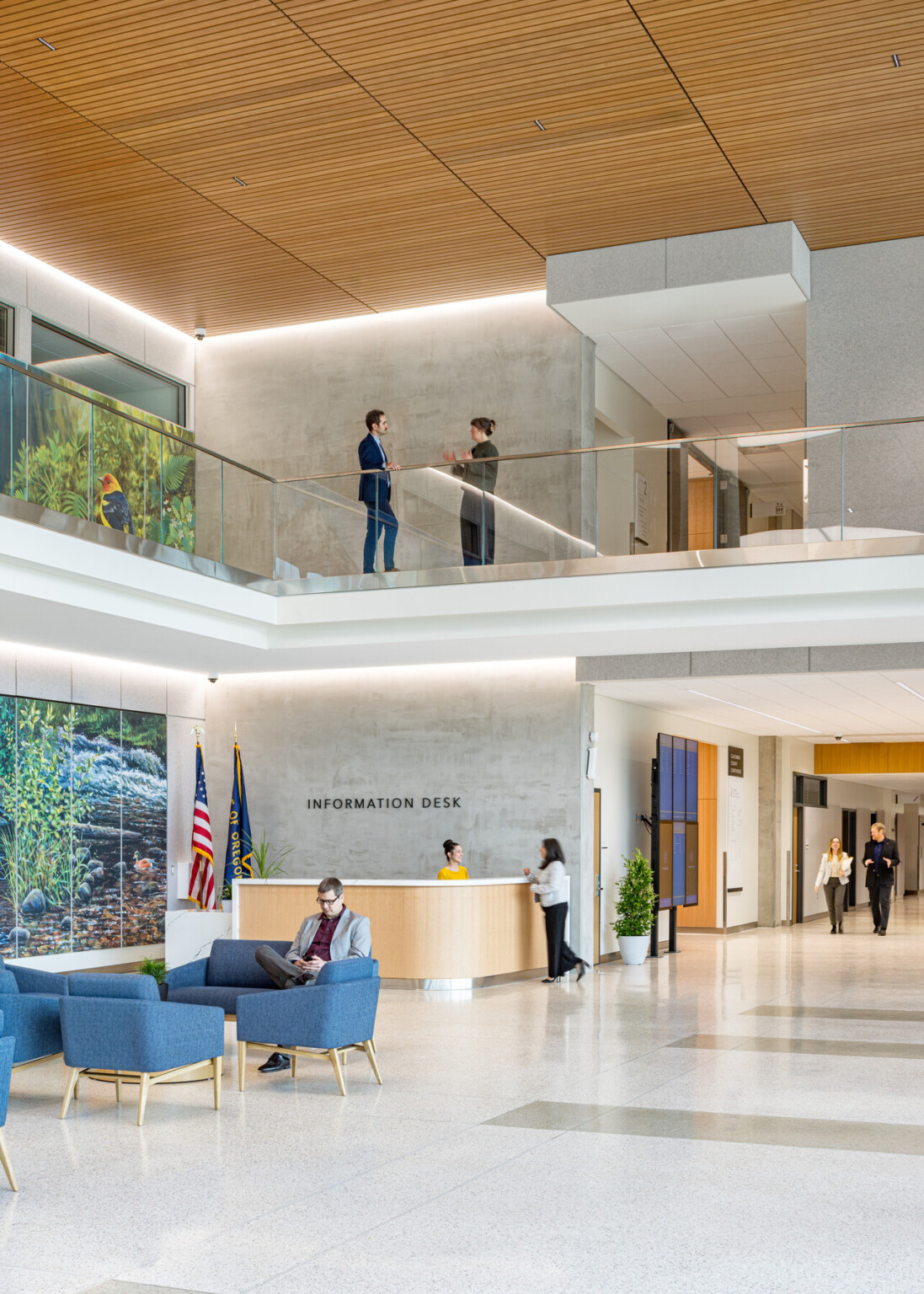 interior lobby of Clackamas County Courthouse; double height space with modern white design; natural and LED lighting; left wall with blue and green mural