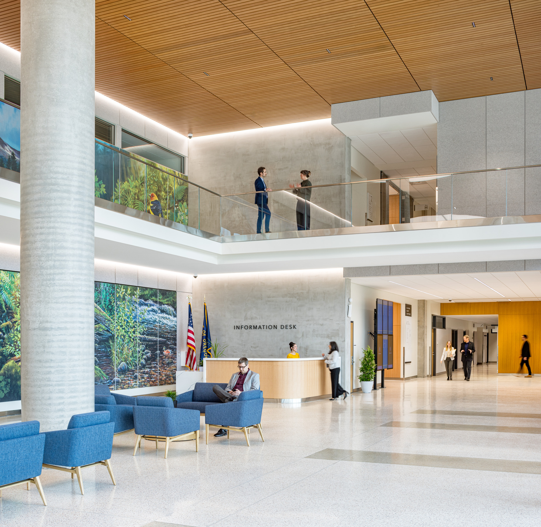 interior lobby of Clackamas County Courthouse; double height space with modern white design; natural and LED lighting; left wall with blue and green mural